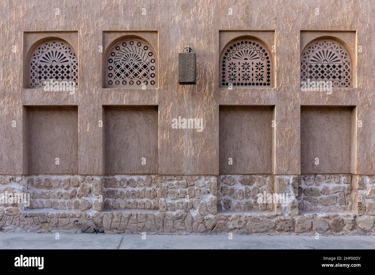 Arabic style window portals in stone wall with ornaments, traditional arabic architecture, Al Fahidi, Dubai, United Arab Emirates. Stock Photo