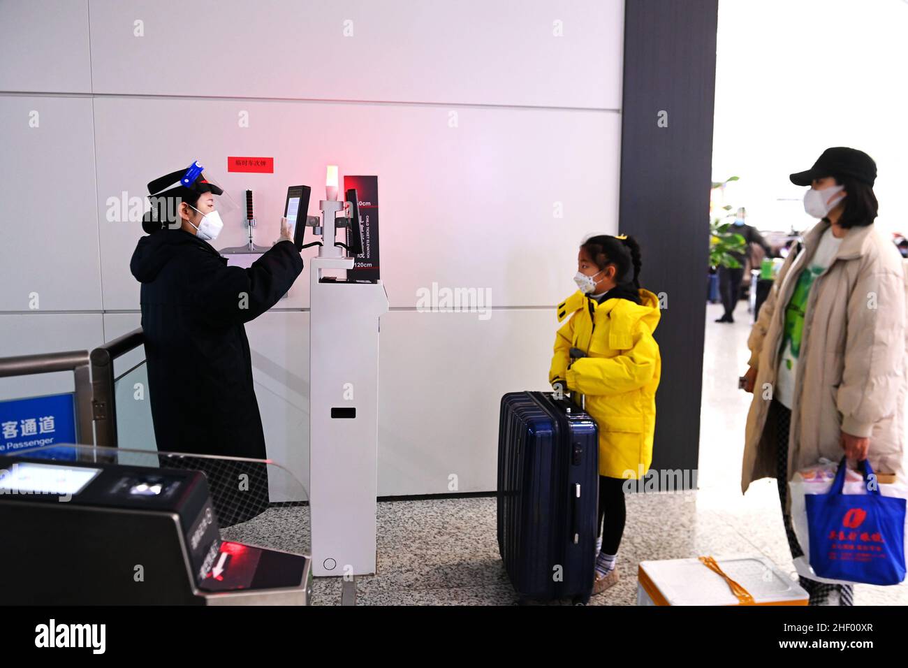 QINGDAO, CHINA - JANUARY 13, 2022 - A ticket inspector checks a passenger's ticket at Qingdao West Railway Station, East China's Shandong Province, Ja Stock Photo