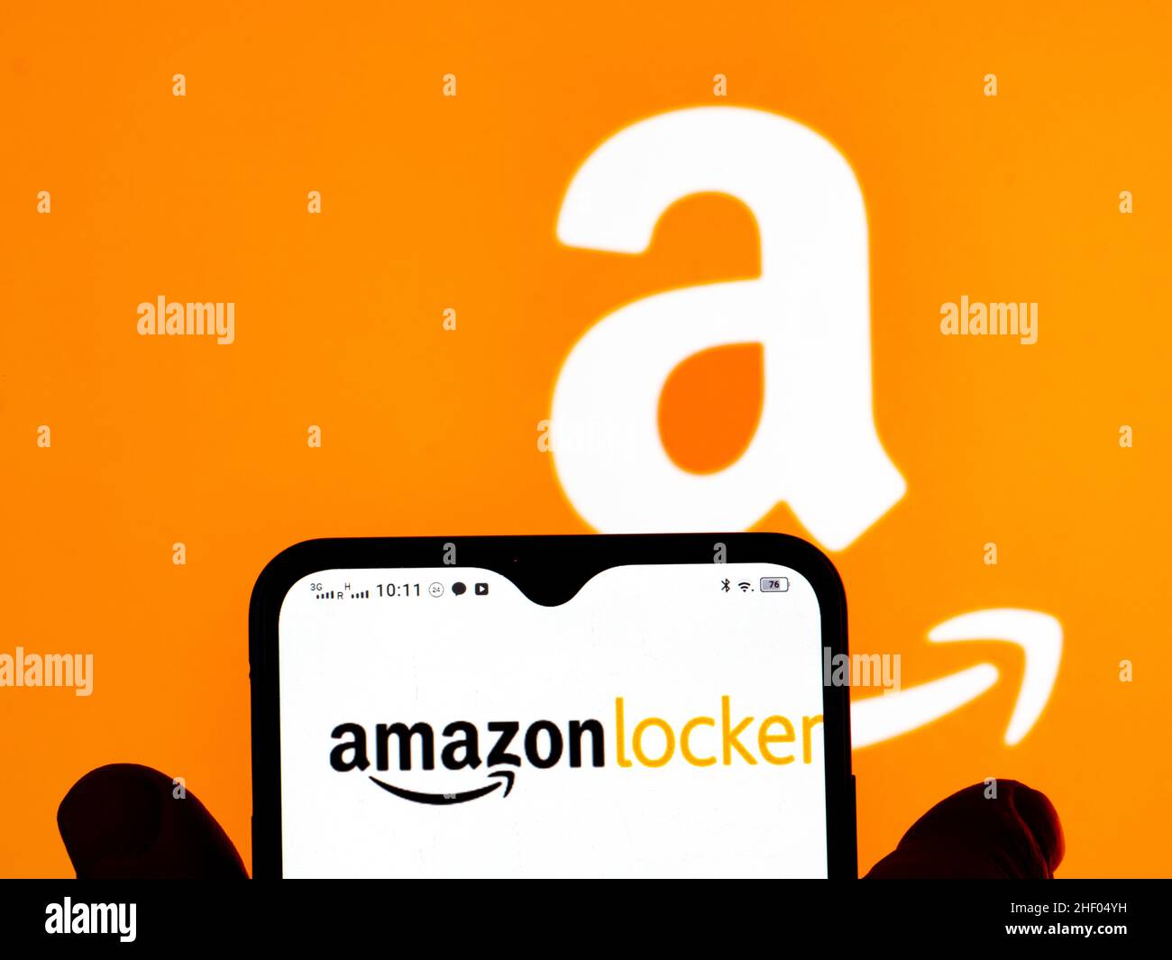 In this photo illustration, the Amazon Locker logo is seen displayed on a smartphone screen and Amazon logo in the background. Stock Photo
