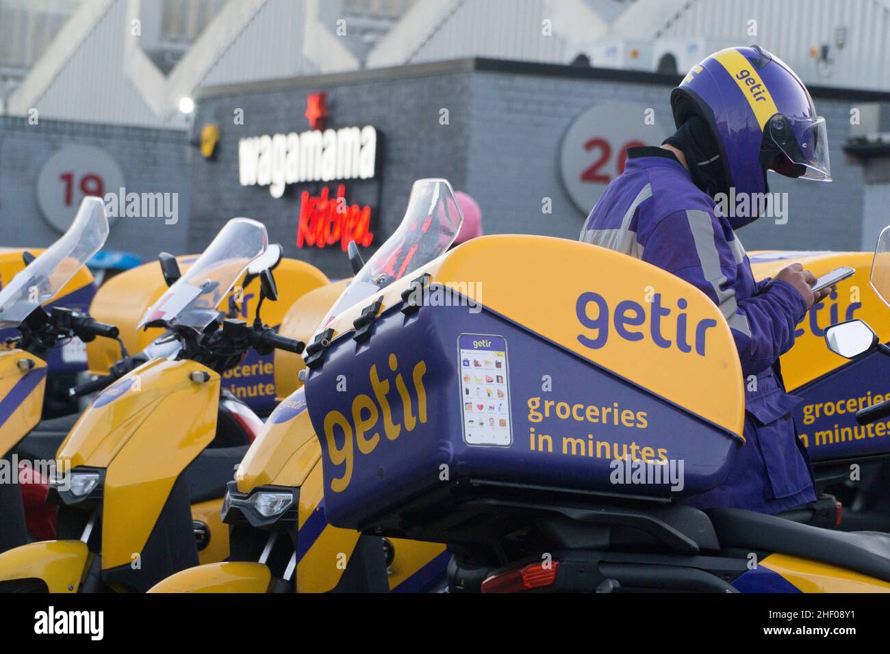 London, UK, 12 January 2022: mopeds belonging to the grocery delivery company Getir outside one of their fulfilment centres on an industrial estate in Clapham. Anna Watson/Alamy Stock Photo