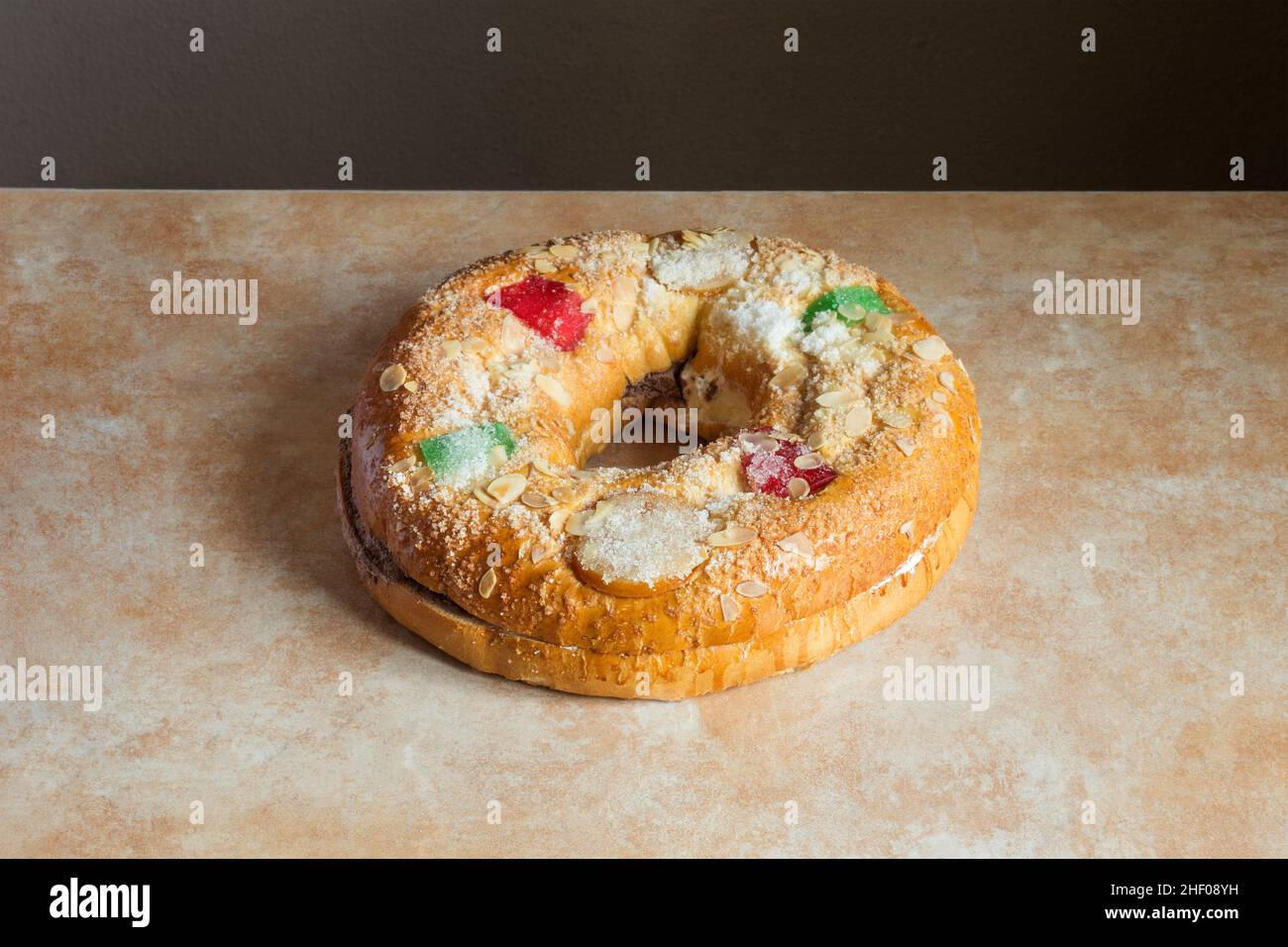 Large donut cake filling with sweet whipped cream with candied fruit adorning the top on an abstract watercolor background. Traditional sweet food on Stock Photo