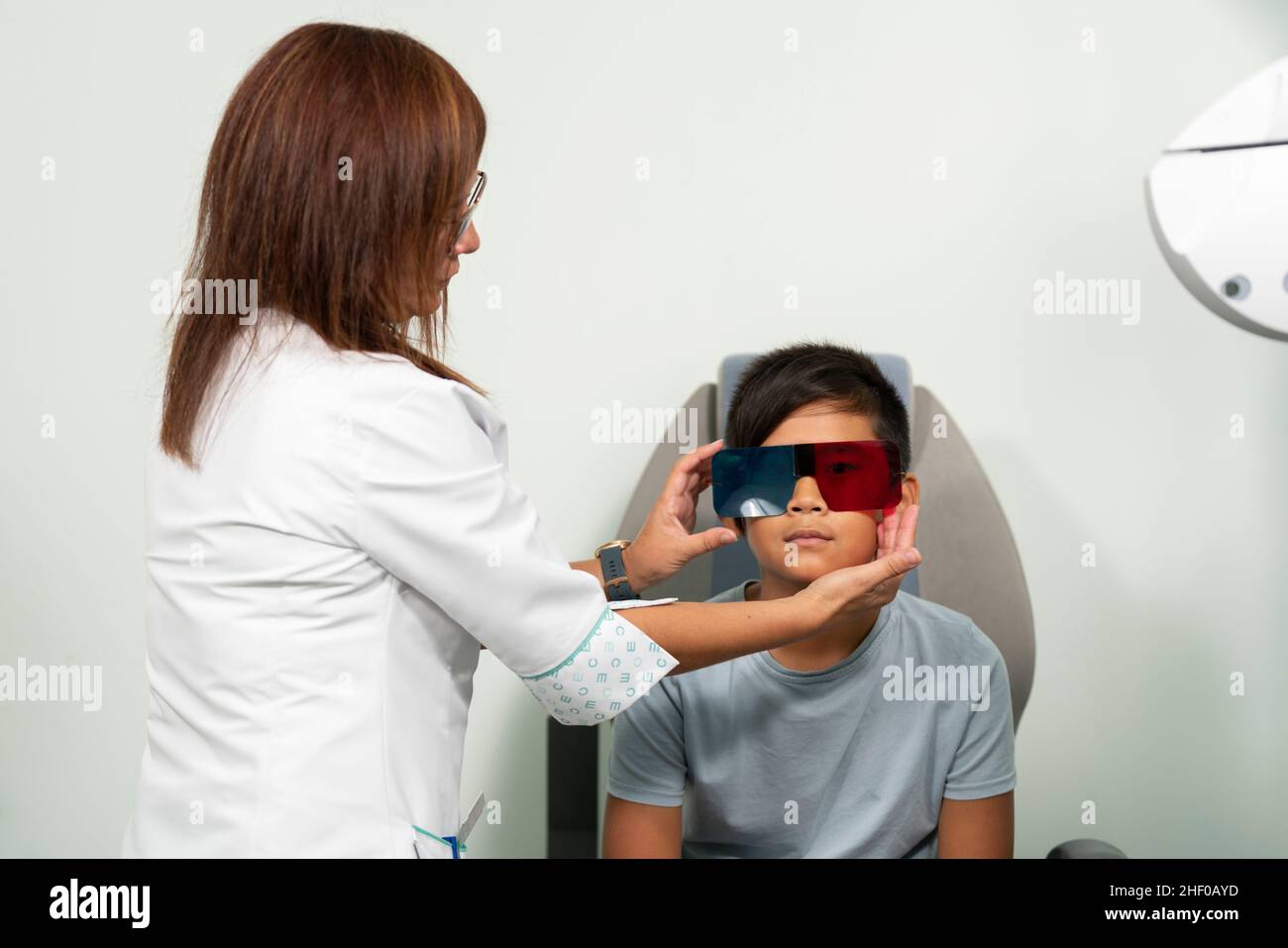 Asian boy in a duochrome test review with red and green 3D glasses Stock Photo
