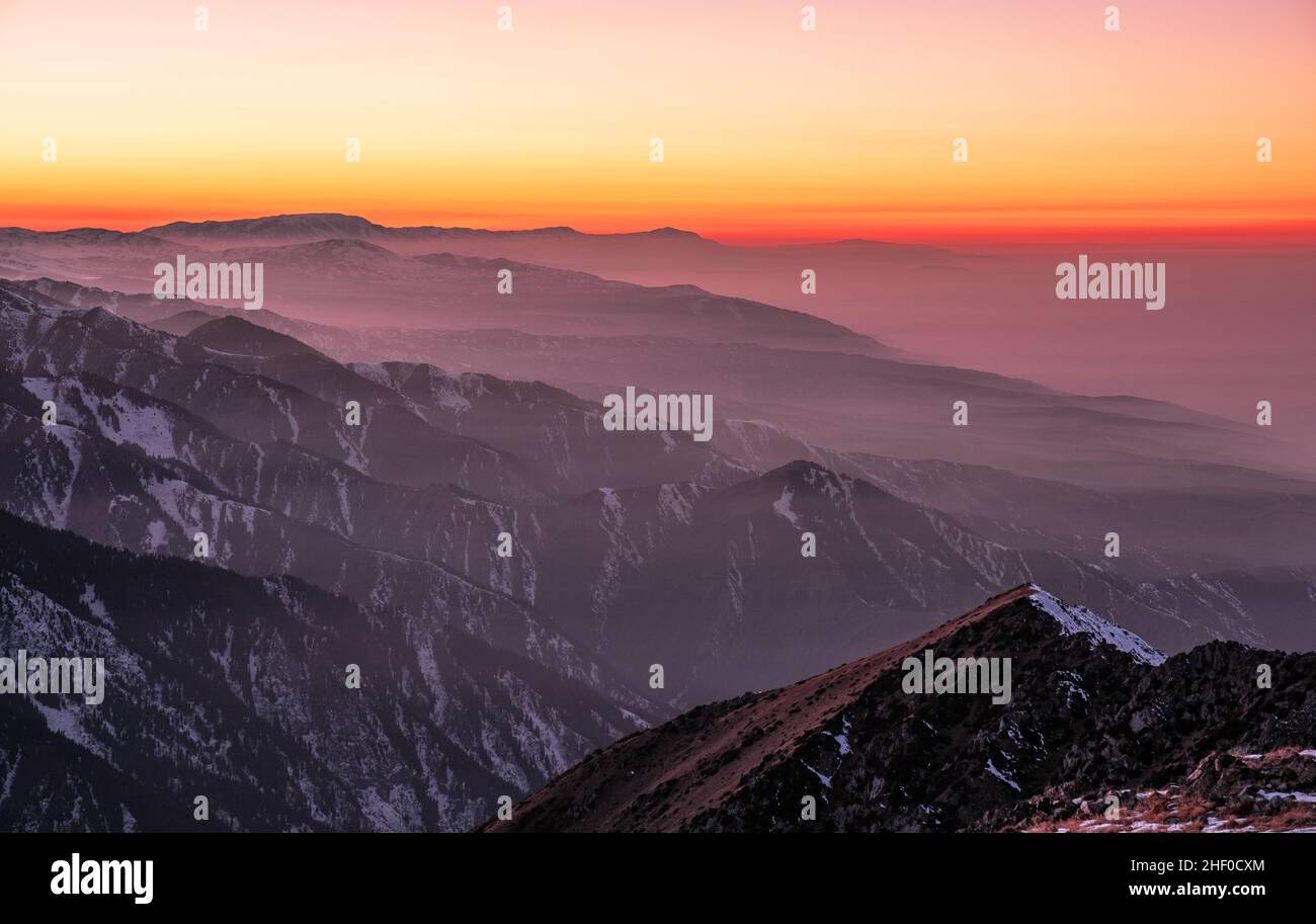 Magical atmosphere of a sunset in the highlands; sunset sky over snow-capped mountain ridges Stock Photo