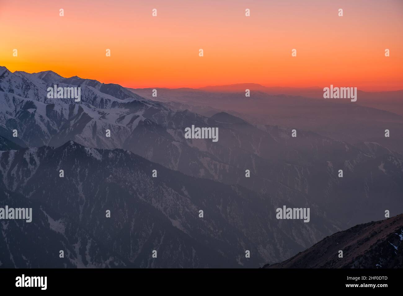 Magical atmosphere of a sunset in the highlands; sunset sky over snow-capped mountain ridges Stock Photo