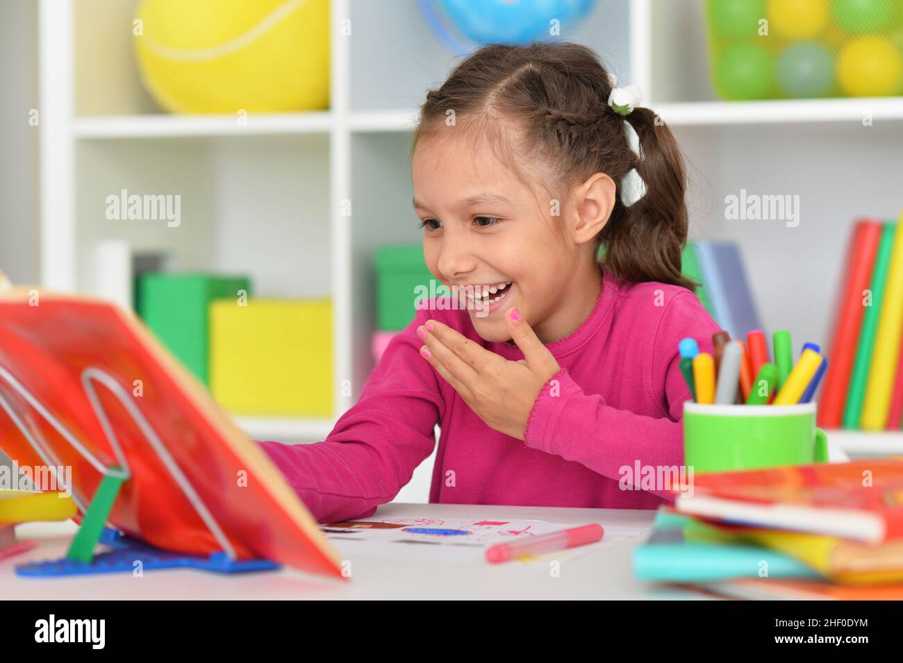 Porait of cute little girl studying at home Stock Photo - Alamy