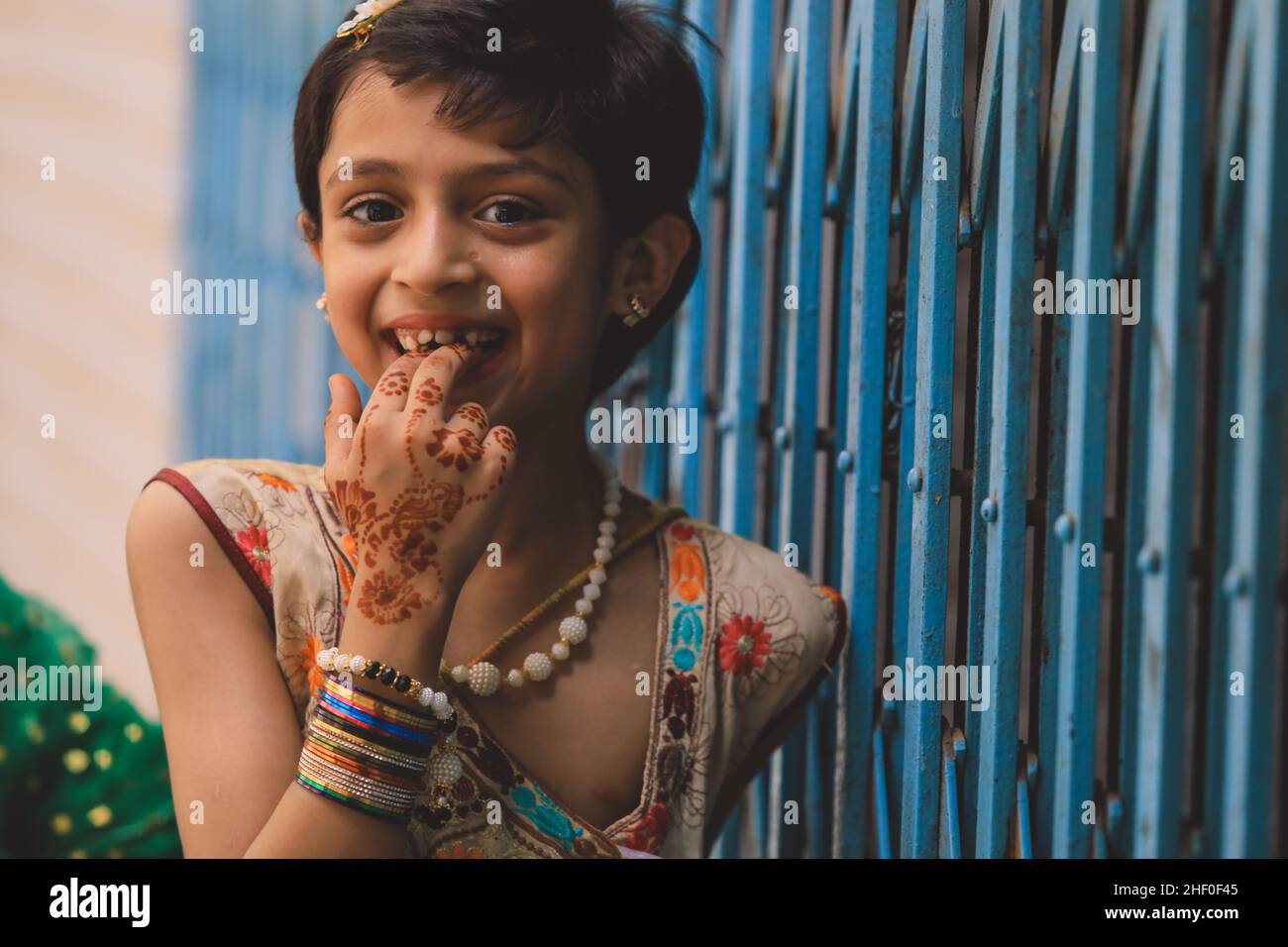 Peshawar, Pakistan - June 08, 2020: Smiling Pakistani Girl with Cut Dark Hair and Colorful Dress Stock Photo
