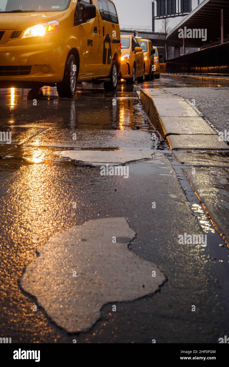 Yellow taxi waiting for the customer in the rain at the exit of the airport in NYC, New York Stock Photo