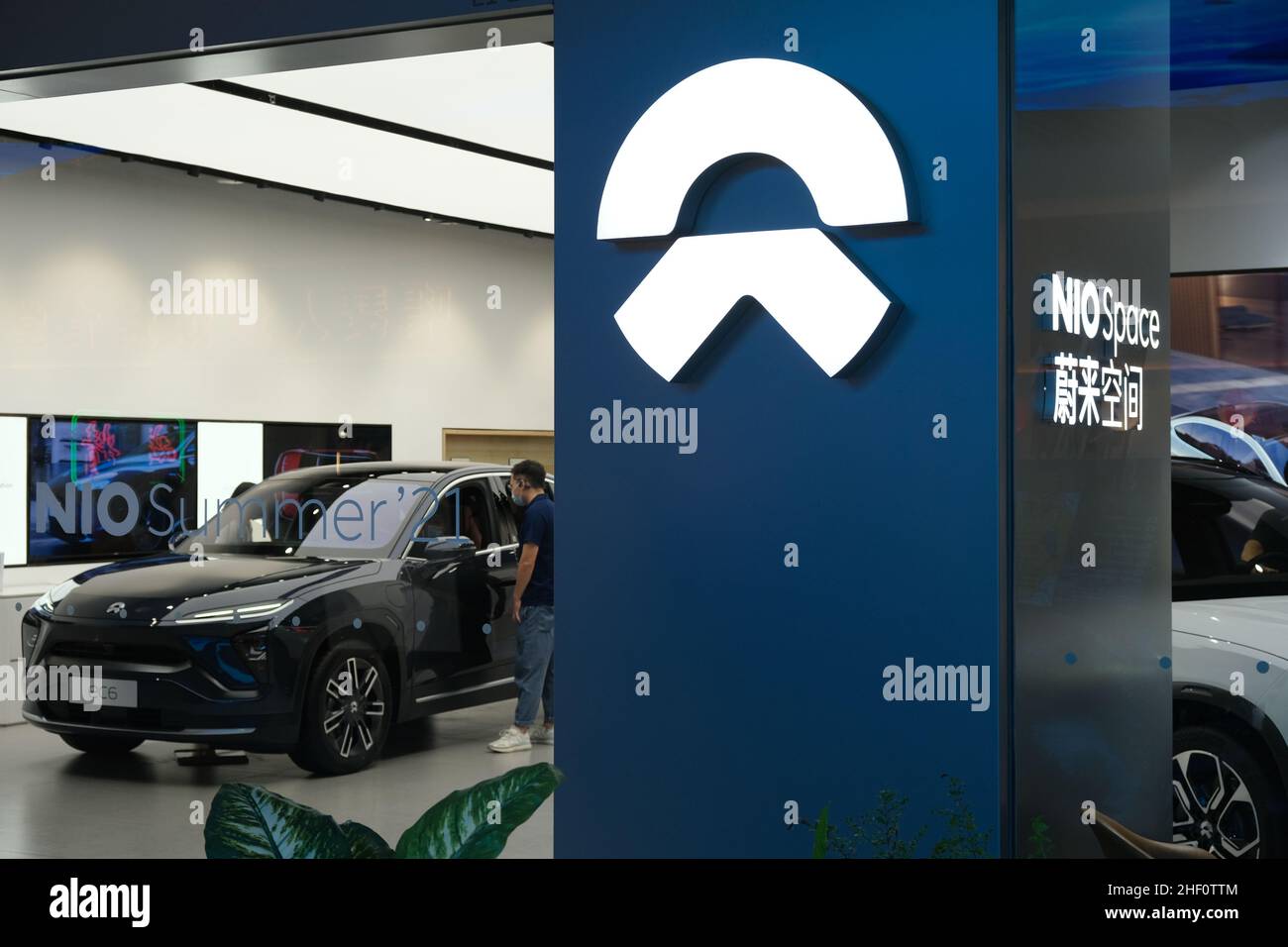NIO store sign and customer in electric car store. NIO is a Chinese EV