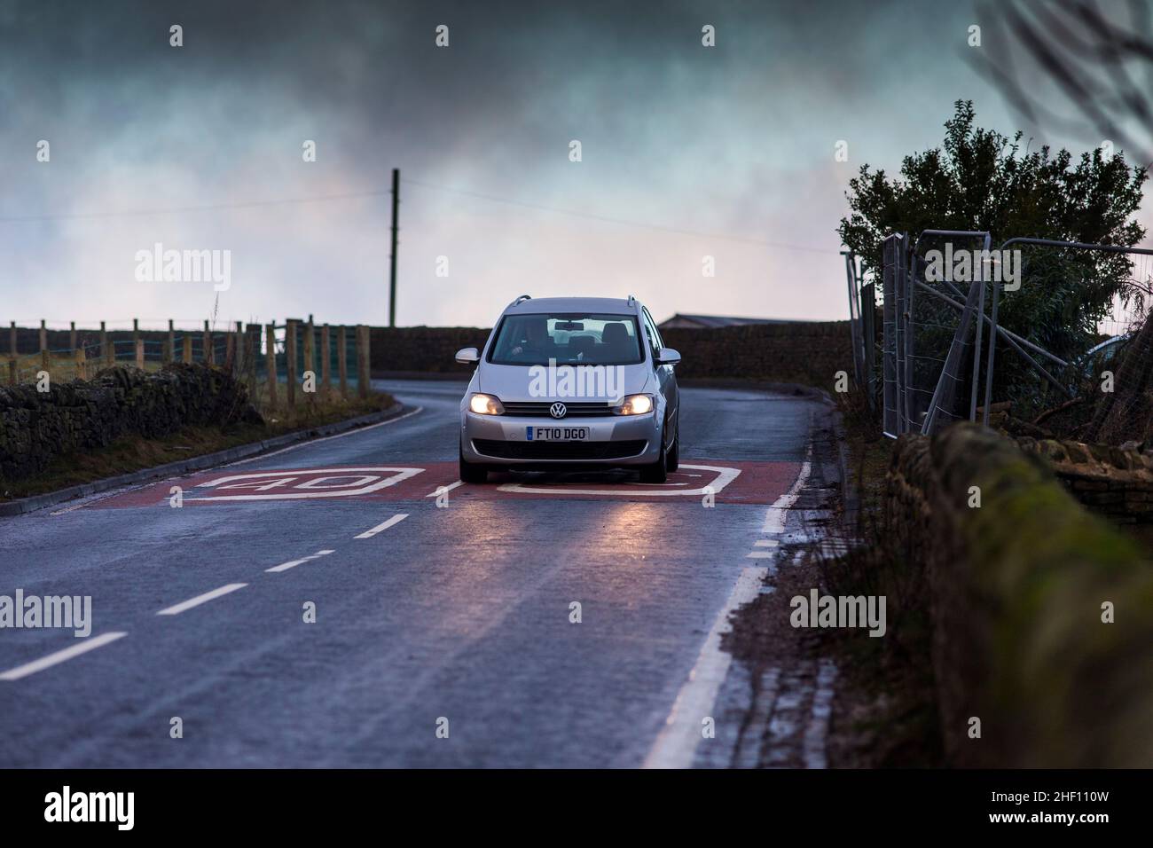 A Volkswagen car brakes as it enters a 40 mph zone above the West
