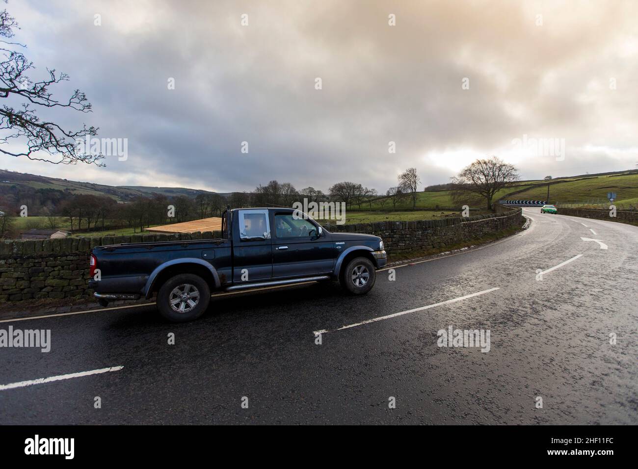 Vehicles negotiate the A6033 above the Pennine village of Oxenhope on a cold January morning in West Yorkshire, UK. Stock Photo