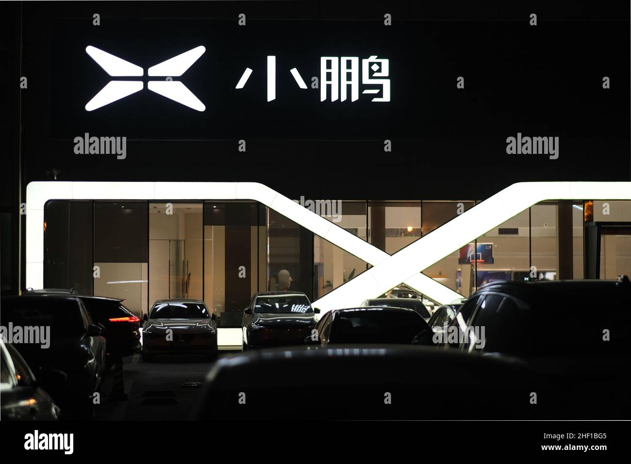 XPeng Motors‘s sales store and service center at night. XPeng's brand logo. A Chinese electric vehicle manufacturer. Stock Photo