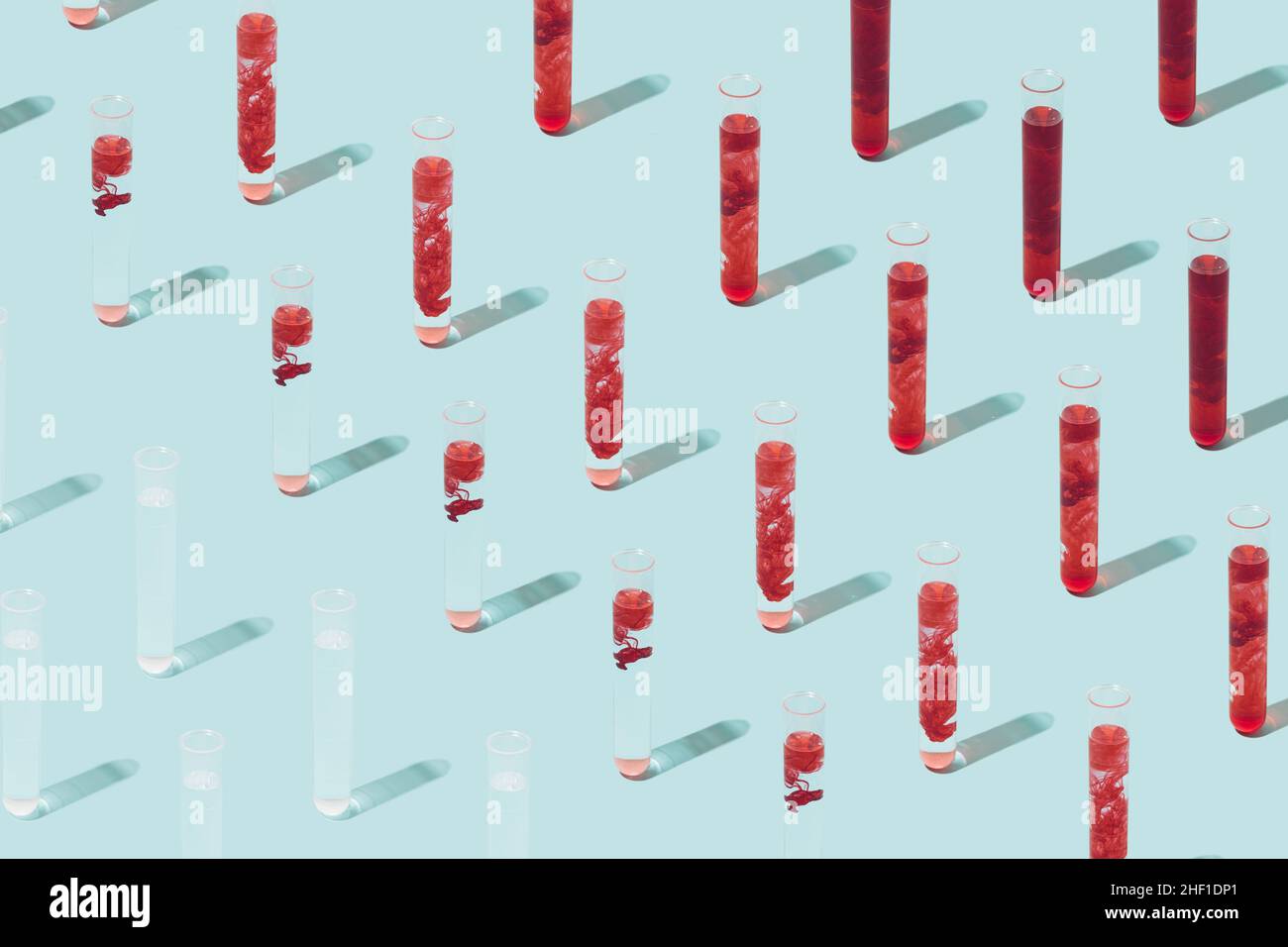Pattern made of various test tubes containing blood on a light blue background. Cure discovery minimal concept. Stock Photo