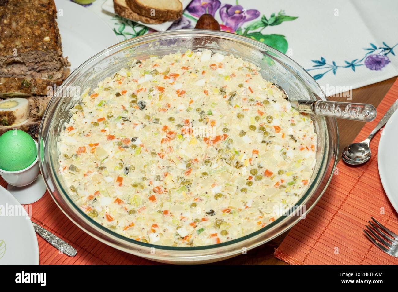 Salade Olivier is a salad composed of diced potato, vegetables and sometimes meats bound in mayonnaise. Stock Photo