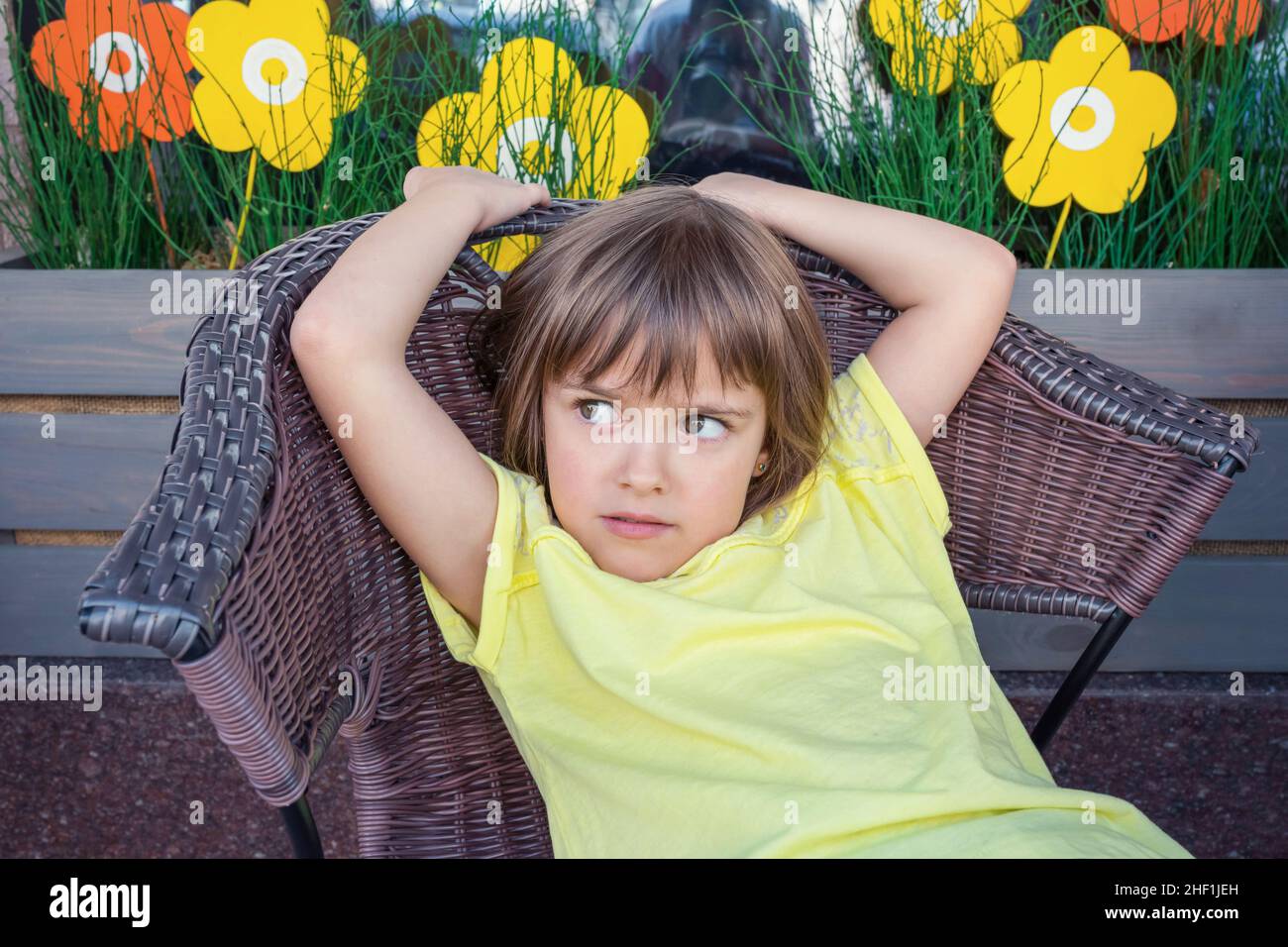 A little girl is sitting in an armchair. Stock Photo