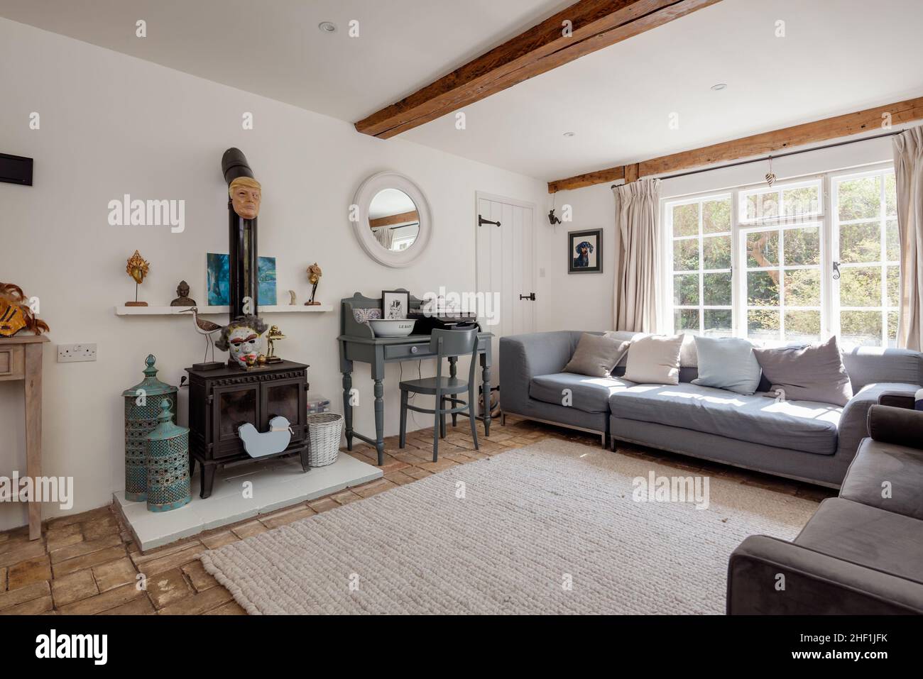 Chilton Street, Suffolk - 20 April 2018: Traditional style farmhouse cottage living room dressed in a sympathetic chic and fashional style with white Stock Photo