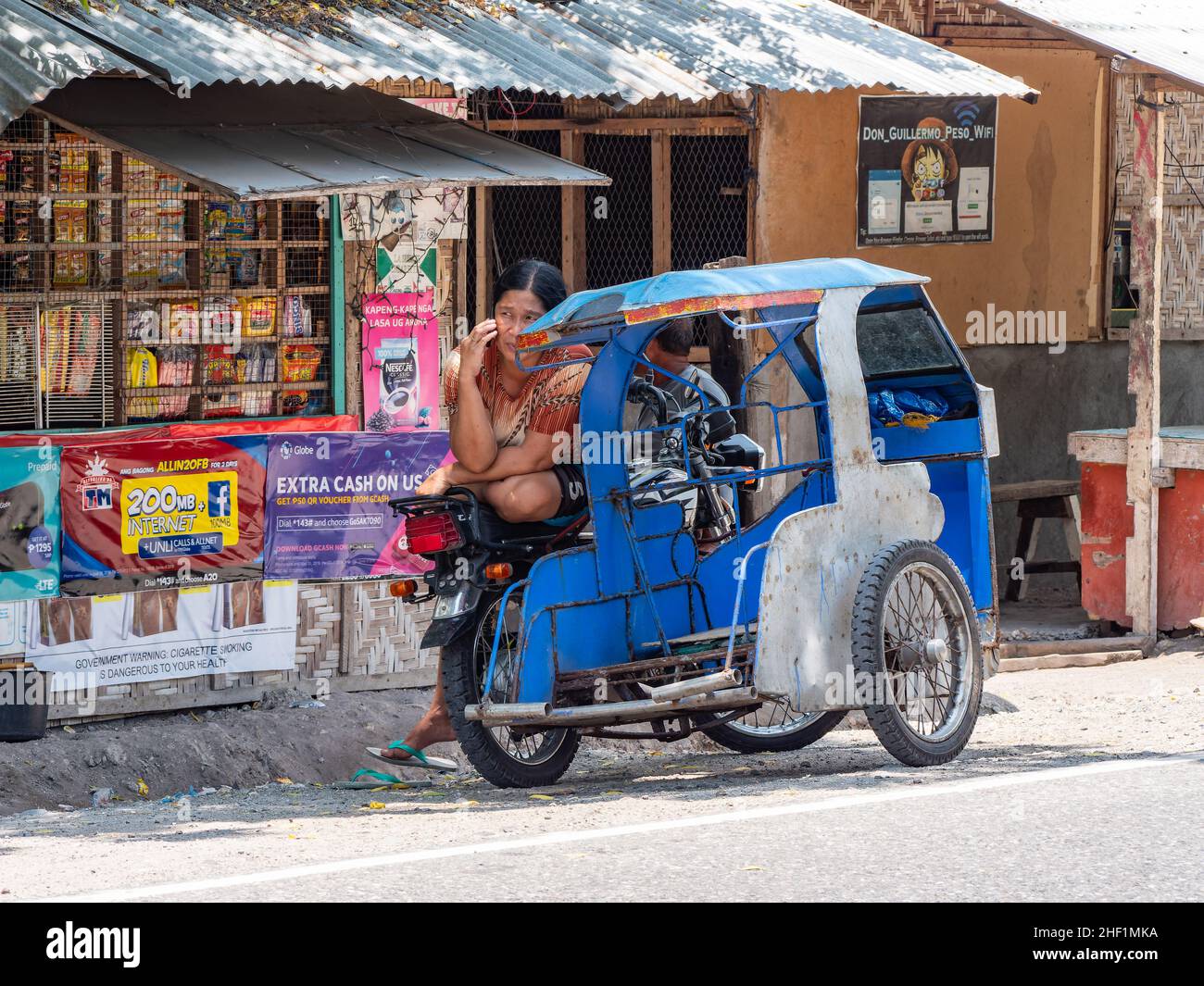 Motorised tricycle and local shop at the village of Tinoto, Maasim in the Sarangani province in southern Mindanao, the Philippines. Stock Photo