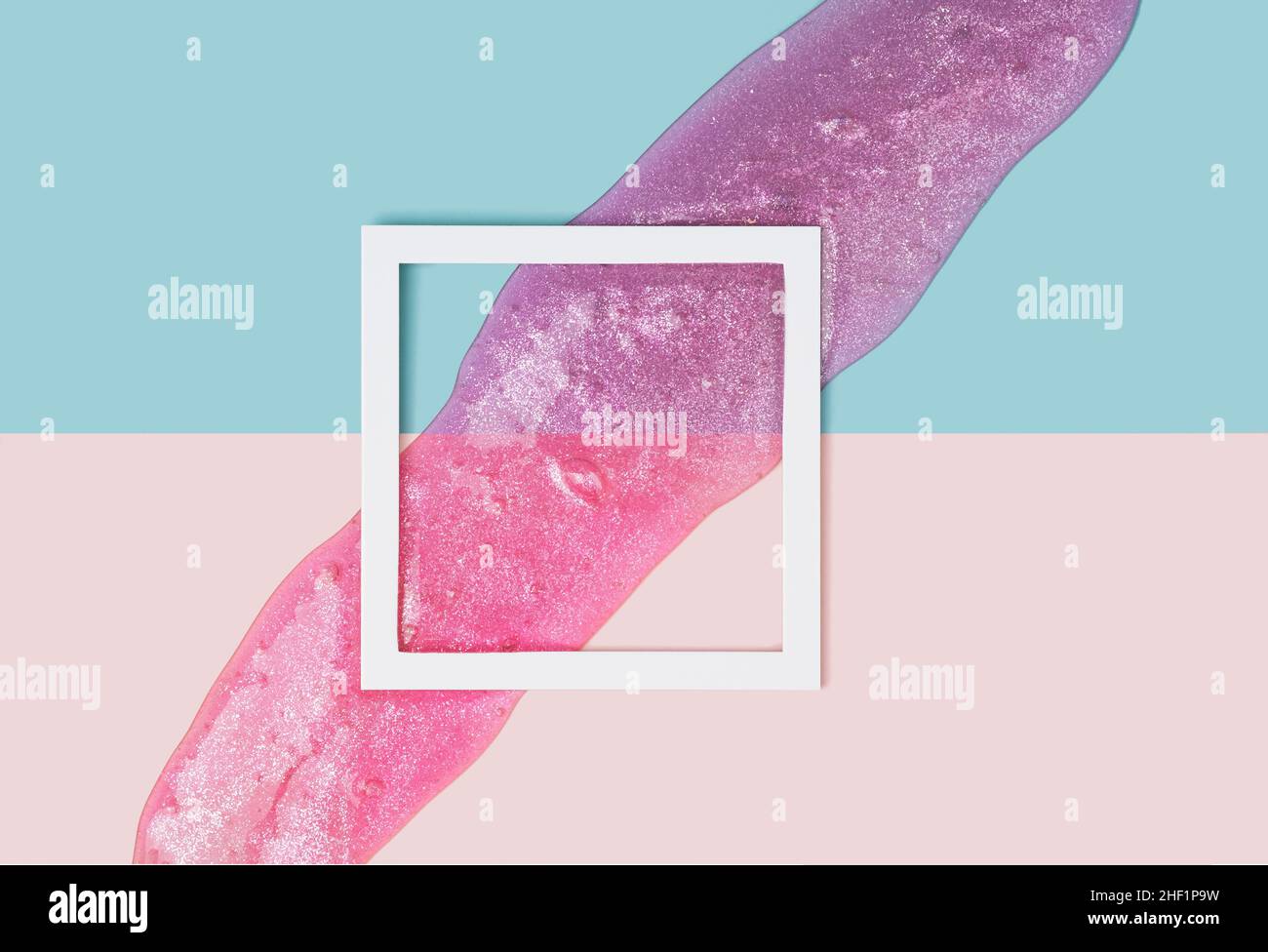 Square frame on a two tone pastel background and violet glitter slime. Futuristic, retro conceptual backdrop. Stock Photo
