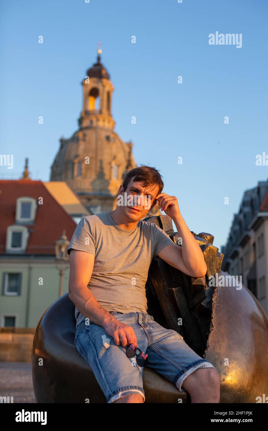person sitting on a sculpture in a city Stock Photo