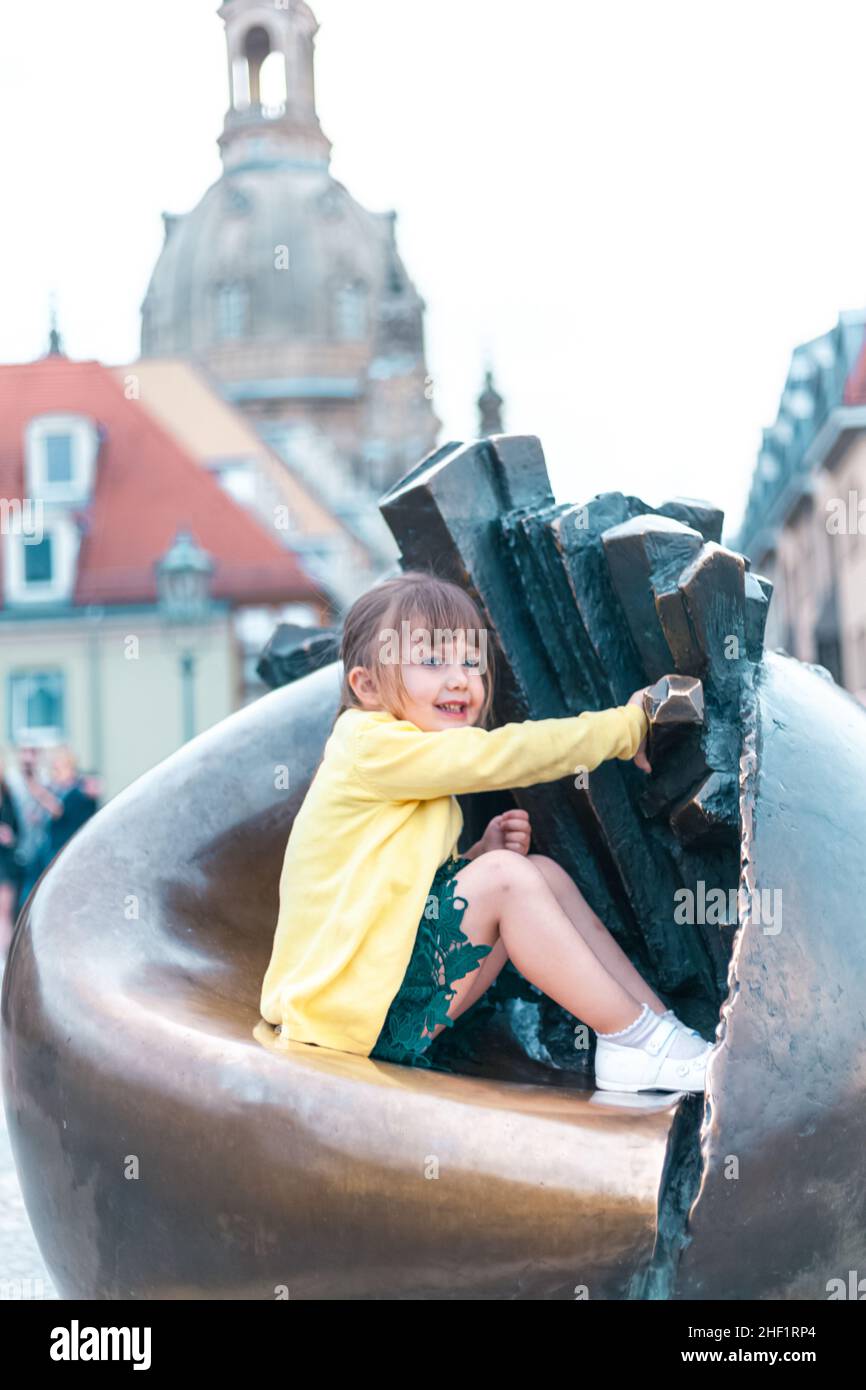 child sitting on a sculpture Stock Photo