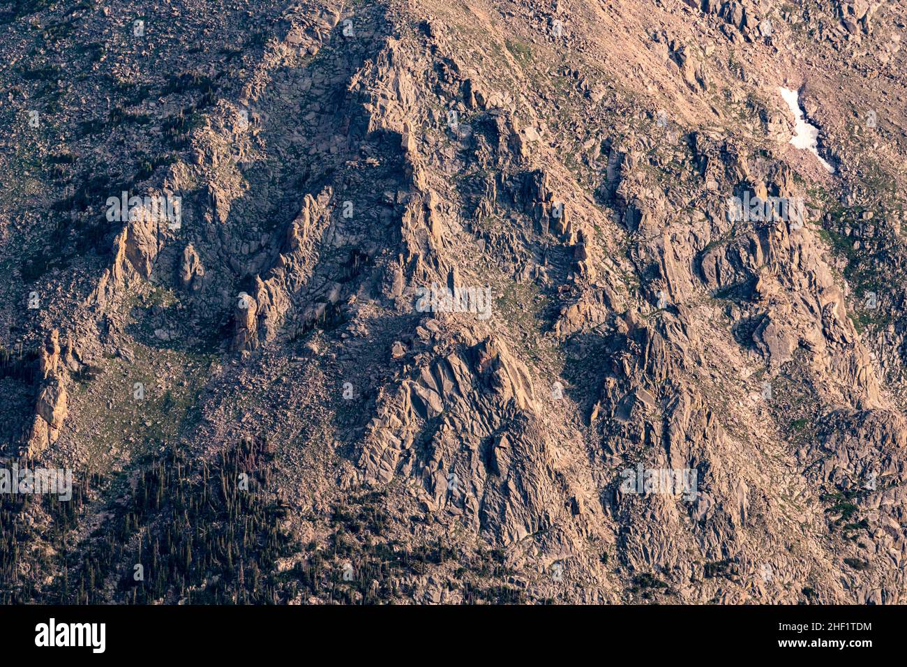 Evening Light Throws Shadows On Rocky Face Of Mountain Side above tree