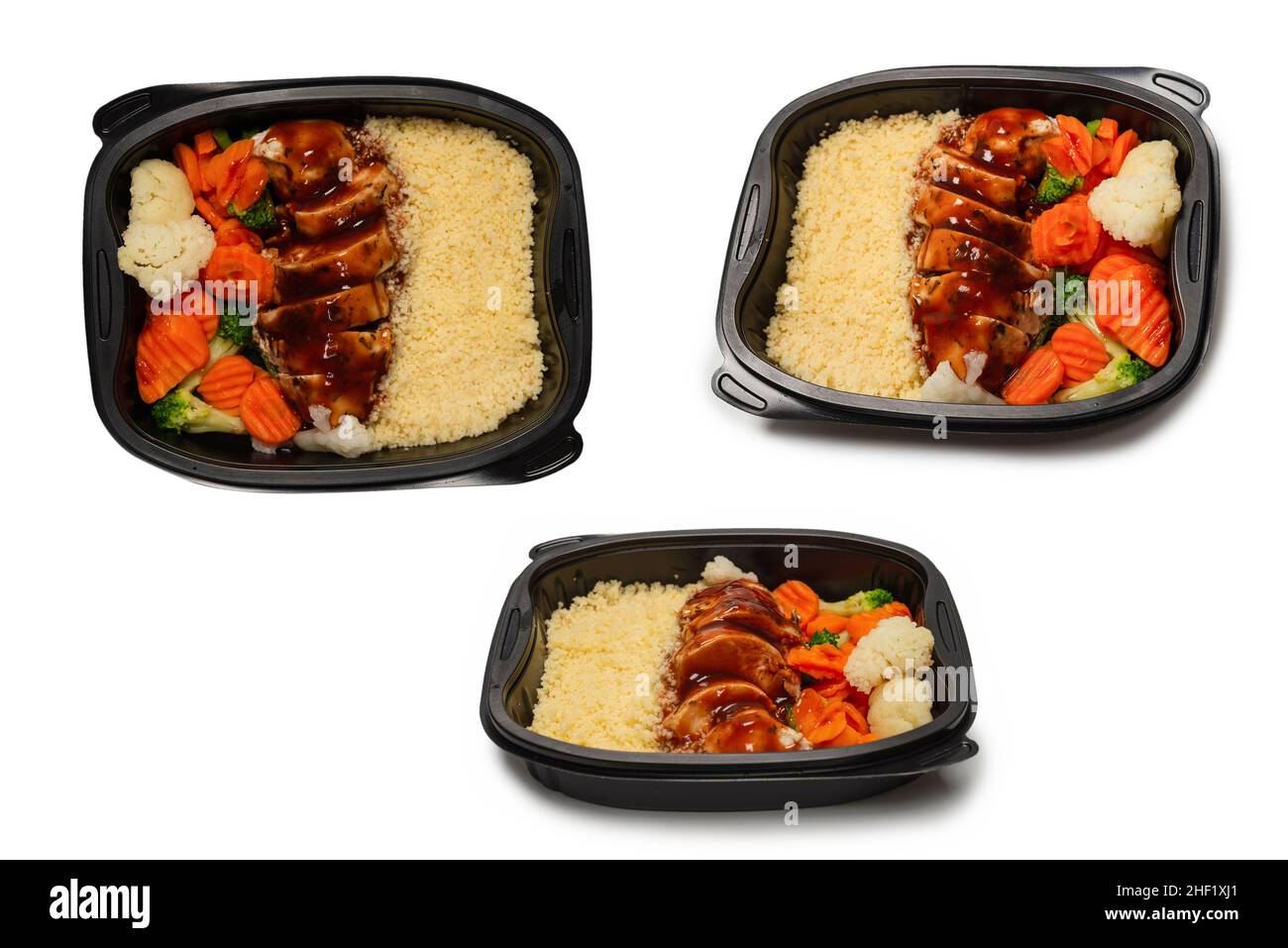 Ready food in a container. Stewed chicken in teriyaki sauce, stewed carrot, cabbage and porridge. Isolated on a white background. Stock Photo