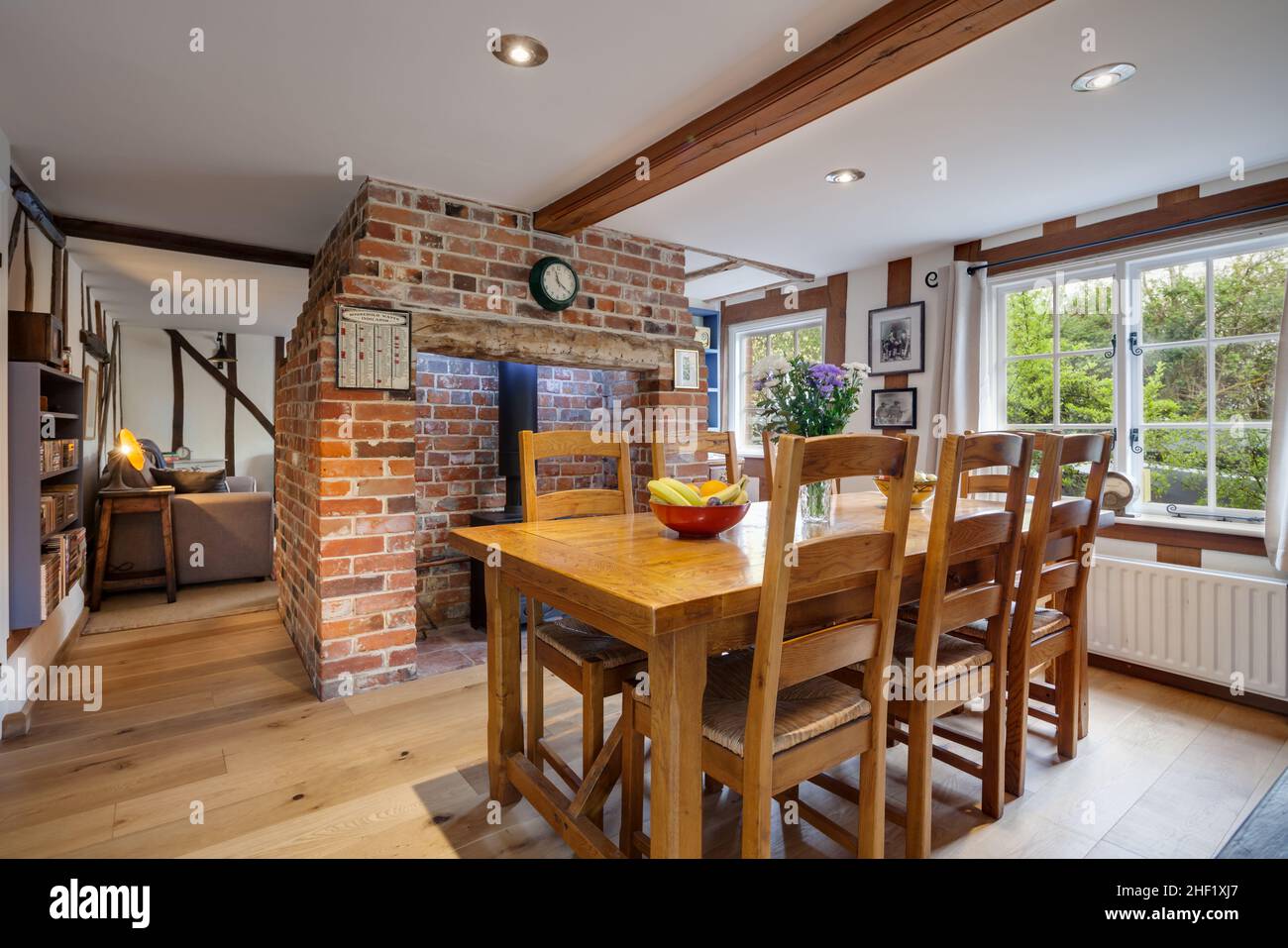 Clare, Suffolk - 27 April 2018: Beautiful, charming, small traditional cottage dining room with exposed brick inglenook fireplace and wooden floor Stock Photo
