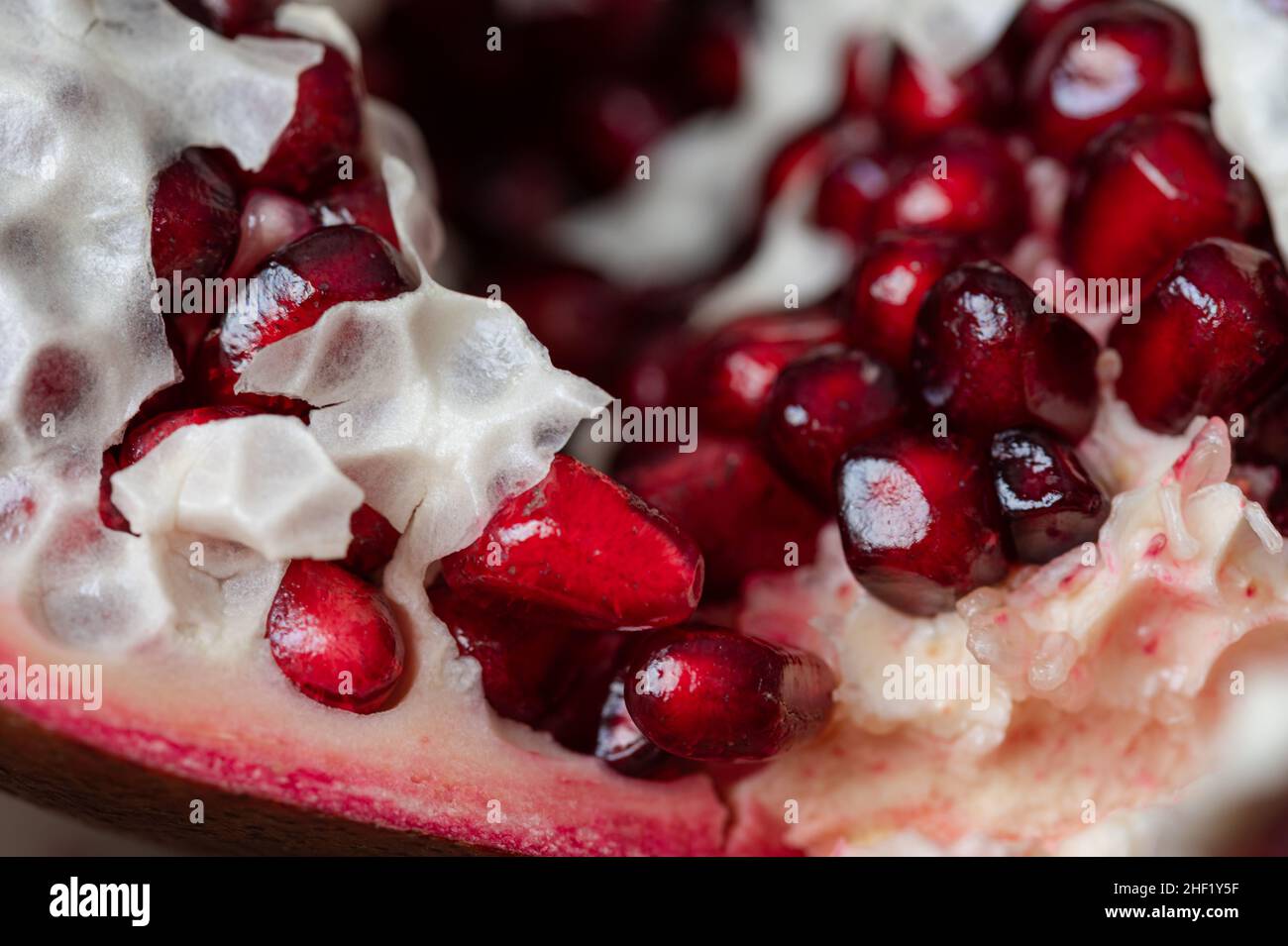 Close Up of a cracked open Pomegranate with seeds and pulp Stock Photo