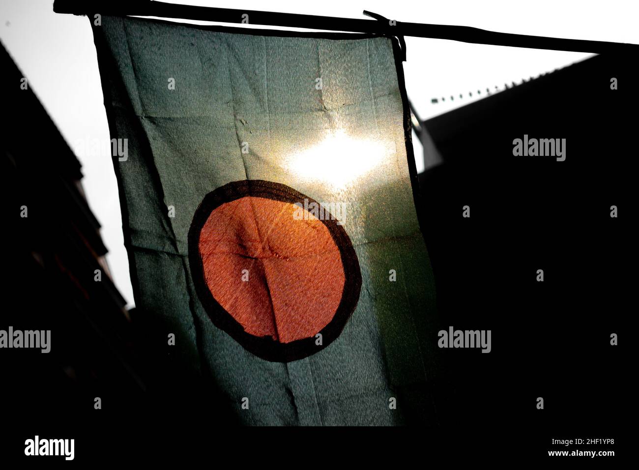 The national flag of Bangladesh is flying in the sky. The flag of Bangladesh is made of a center red circle in green. Close Up View of the national fl Stock Photo