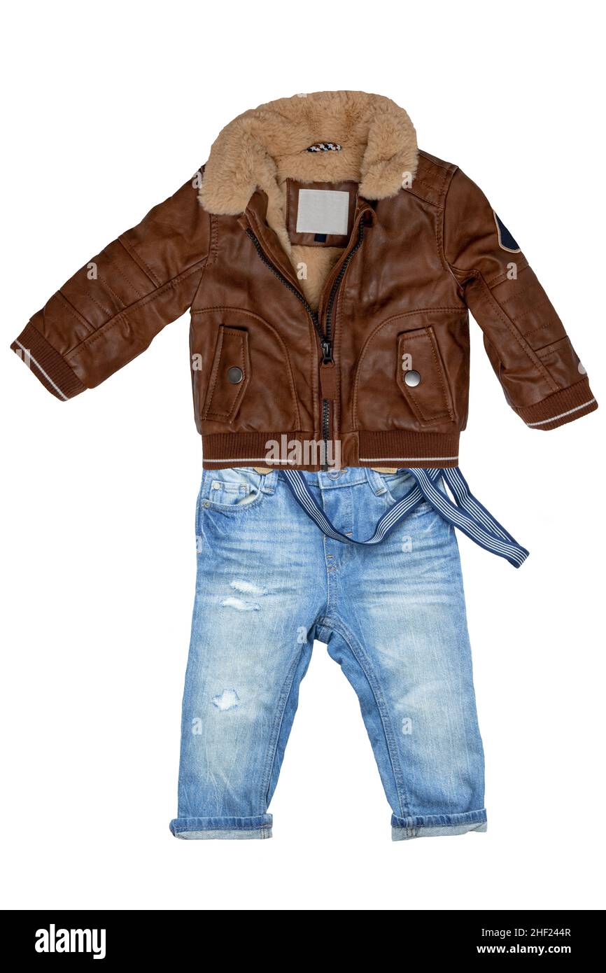 Closeup of a trendy stylish brown leather jacket with fur and a blue denim pants or trousers for child boy isolated on a white background. Jeans autum Stock Photo