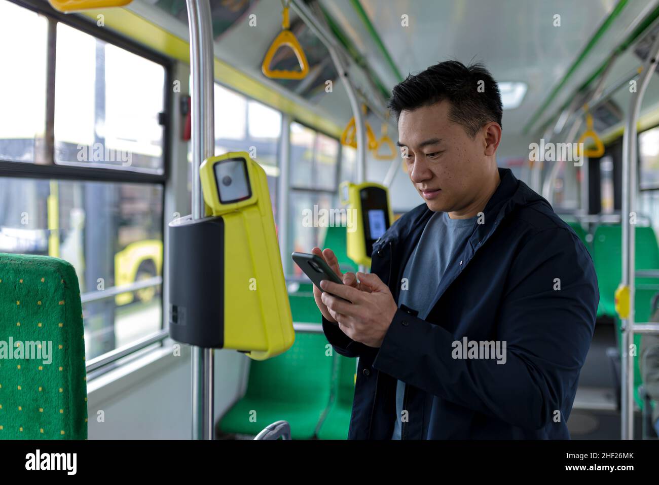 Happy and successful asian male passenger in public transport bought a