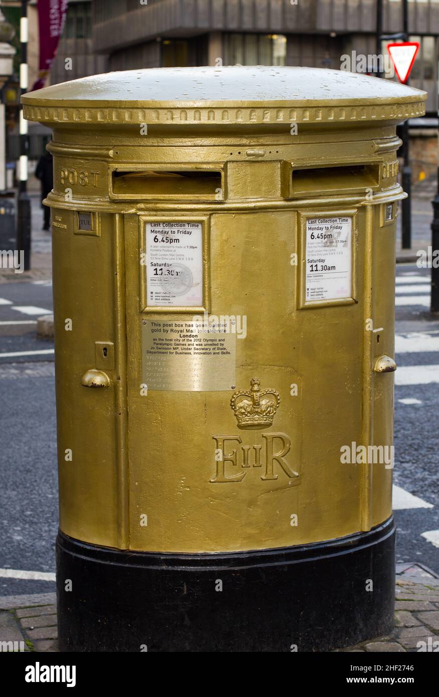 A Post Office Royal Mail post box painted gold to commemorate the London Olympic Games 2012 and gold medal winners.  The Summer Olympics Stock Photo