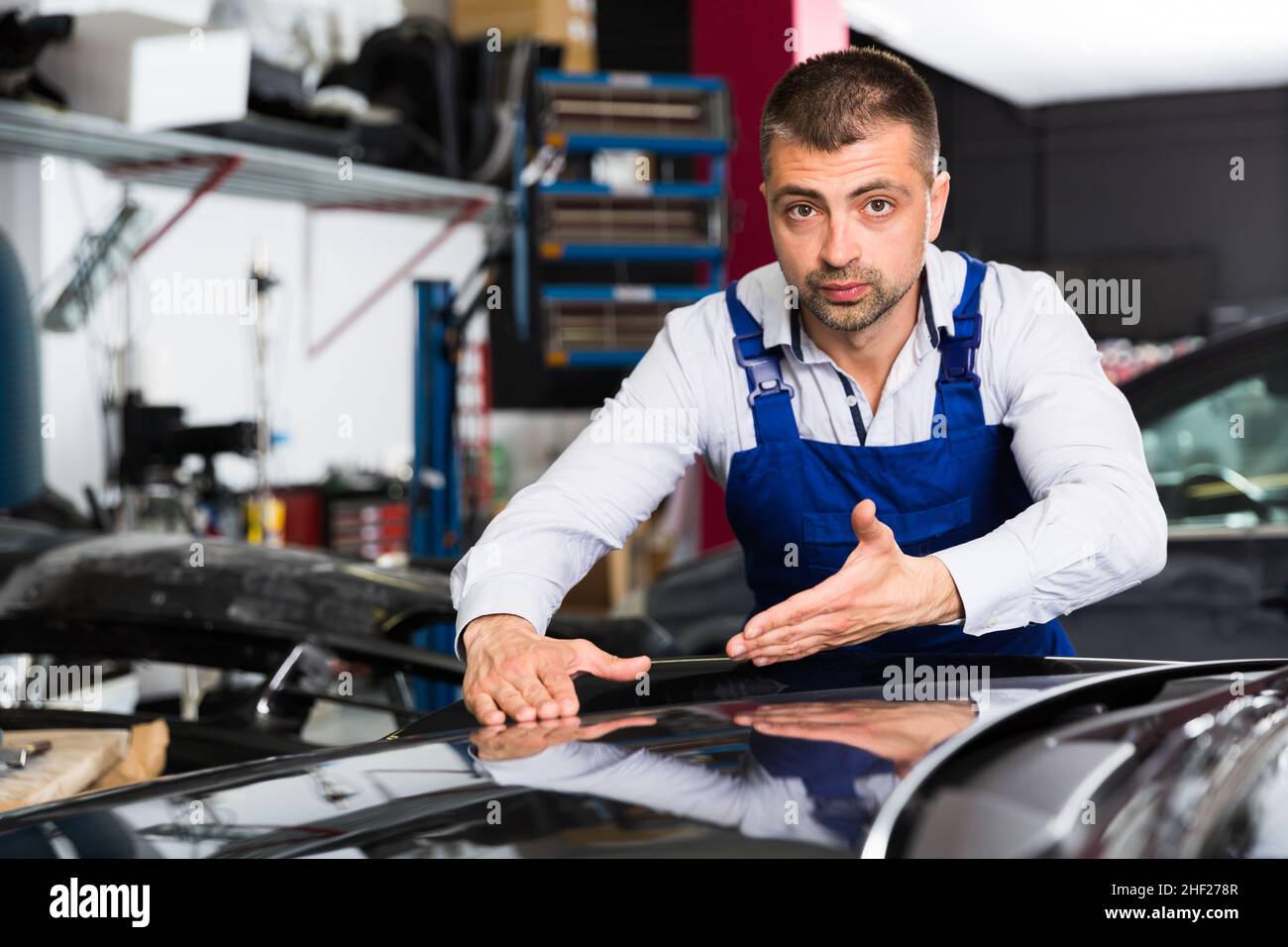 Mechanic demonstrating repainted car Stock Photo Alamy