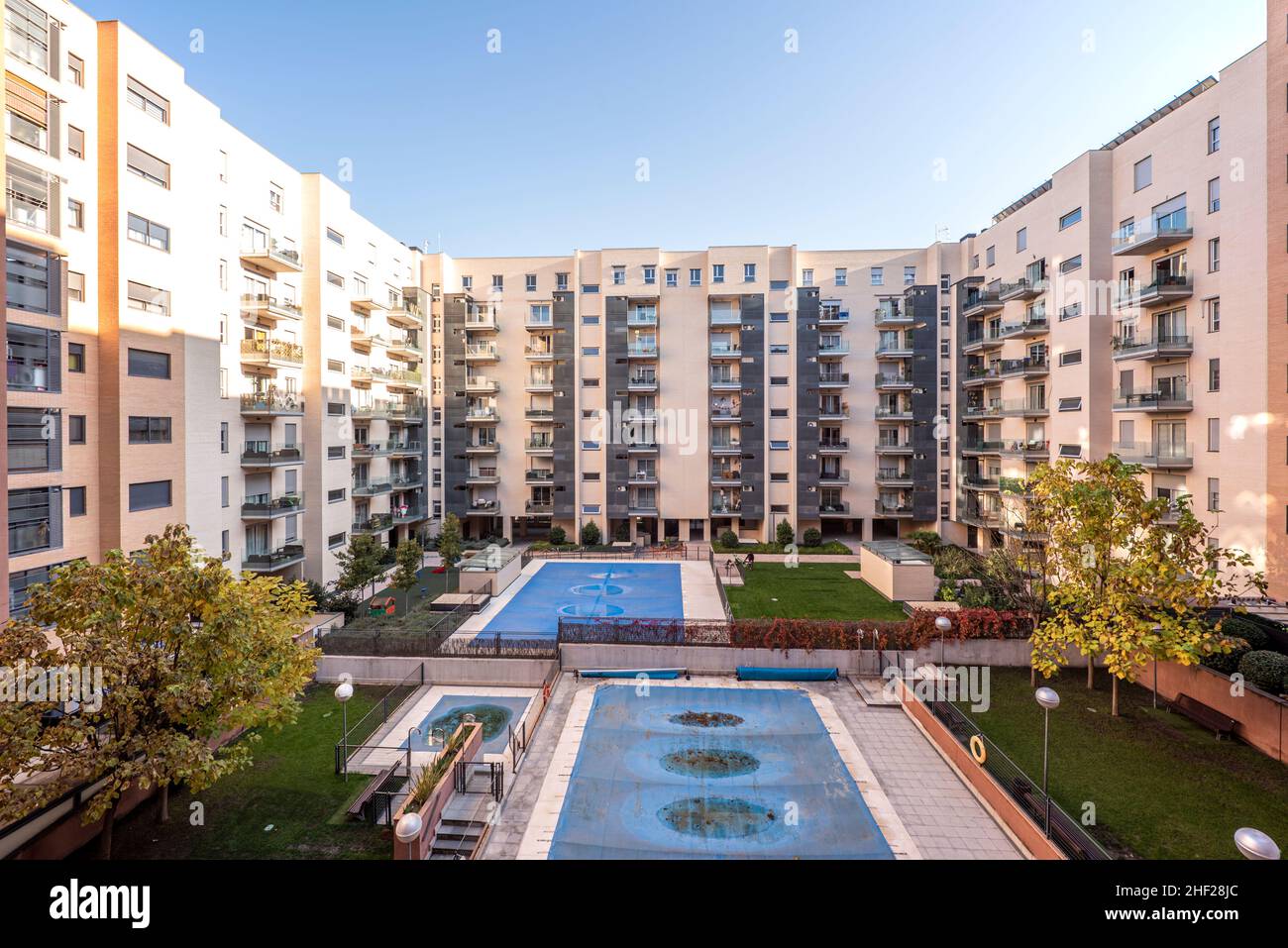 Interior facade of a block patio with communal pools covered with tarps Stock Photo