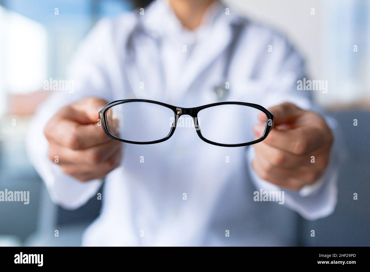 Closeup photo of doctor's hands holding eyeglasses, ophthalmologist