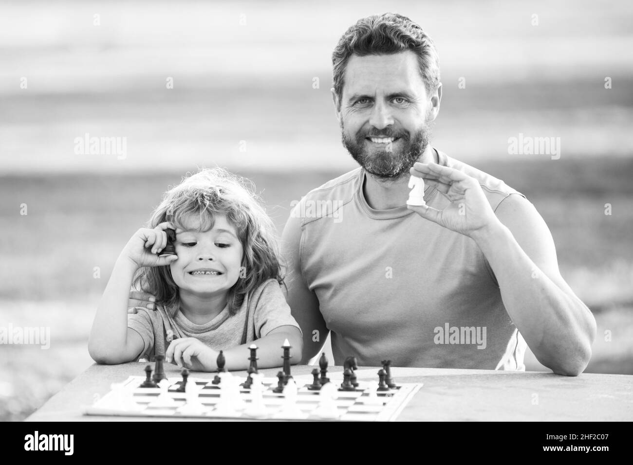 Father play chess with son. Family outside game. Kid boy play chess. Stock Photo