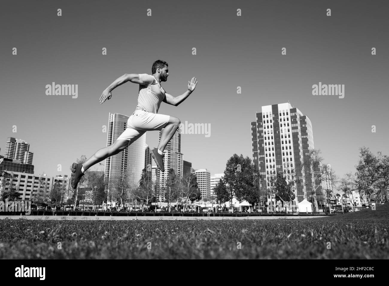 Sporty man runner running in San Diego city. Stock Photo