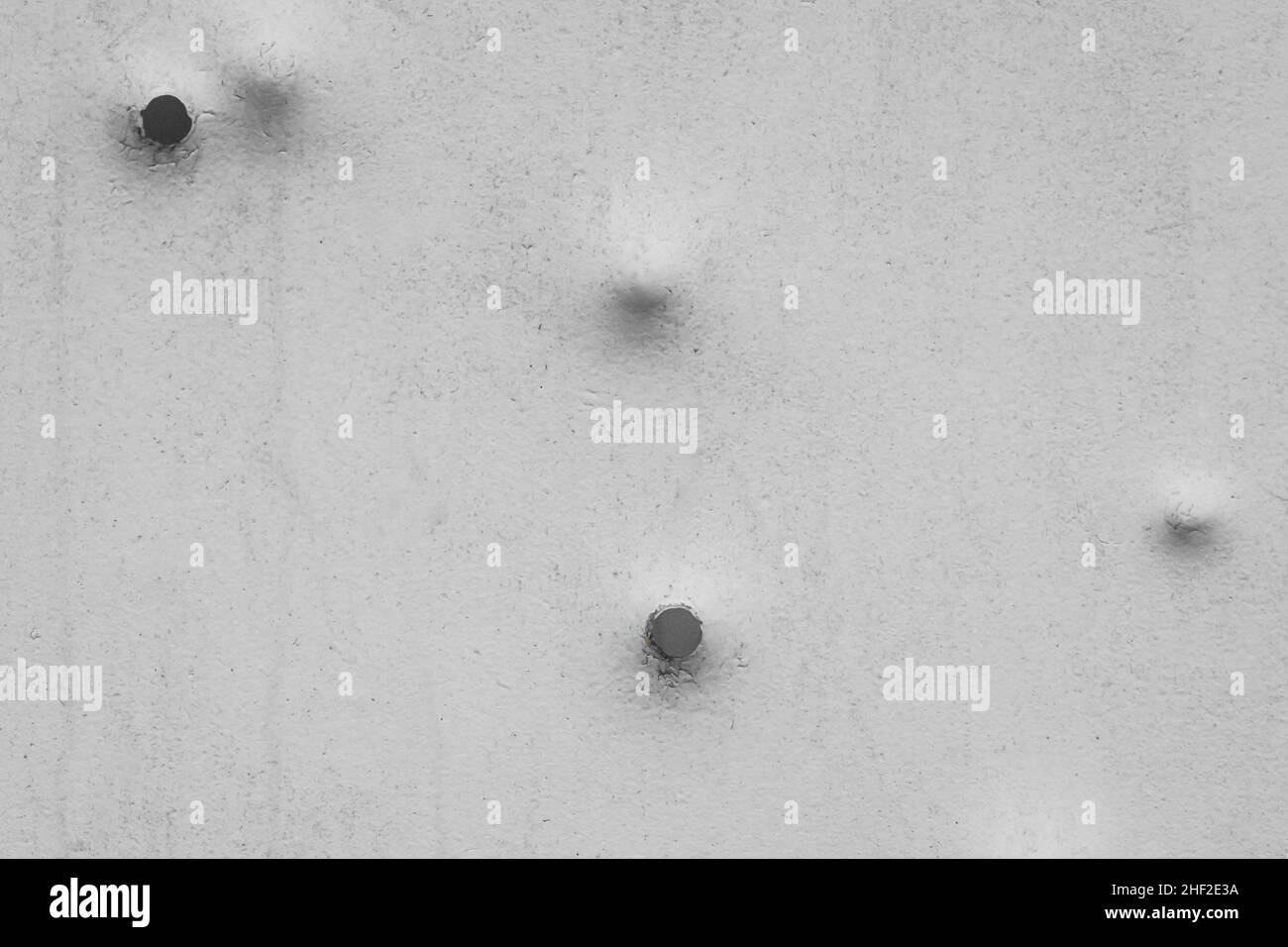 Dents pattern, holes or bullet shot marks on the metal surface of the old background iron texture steel. Stock Photo