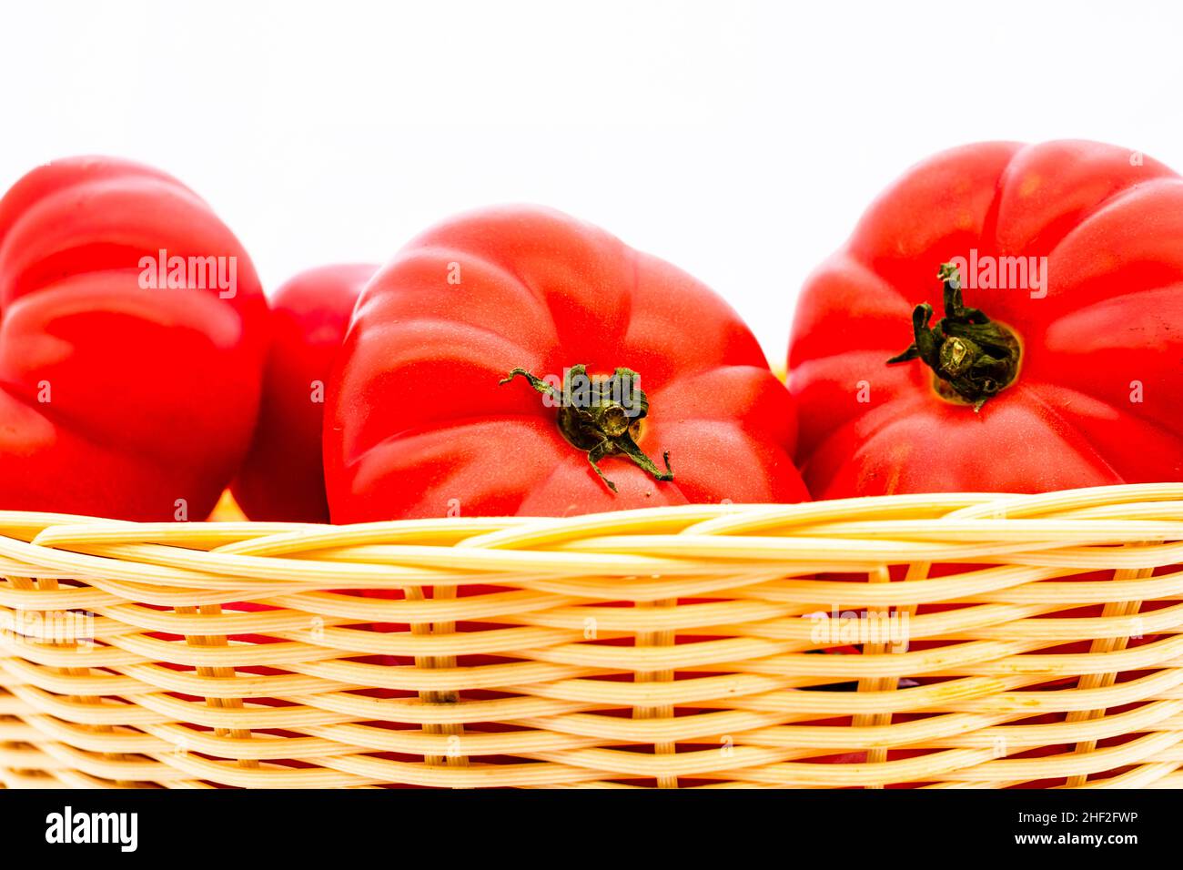 Fresh and tasty red tomatoes in wicker basket isolated Stock Photo - Alamy