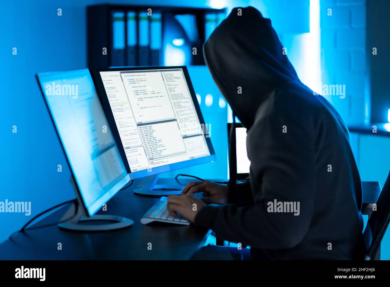 Hacker Using Computer To Write Cyber Security Exploit Software Program Stock Photo