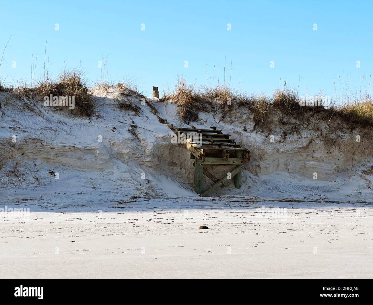 Damaged by ongoing erosion due to storms and rising sea levels, beach access steps have been washed at the south end of Jekyll Island, Georgia, USA. Stock Photo