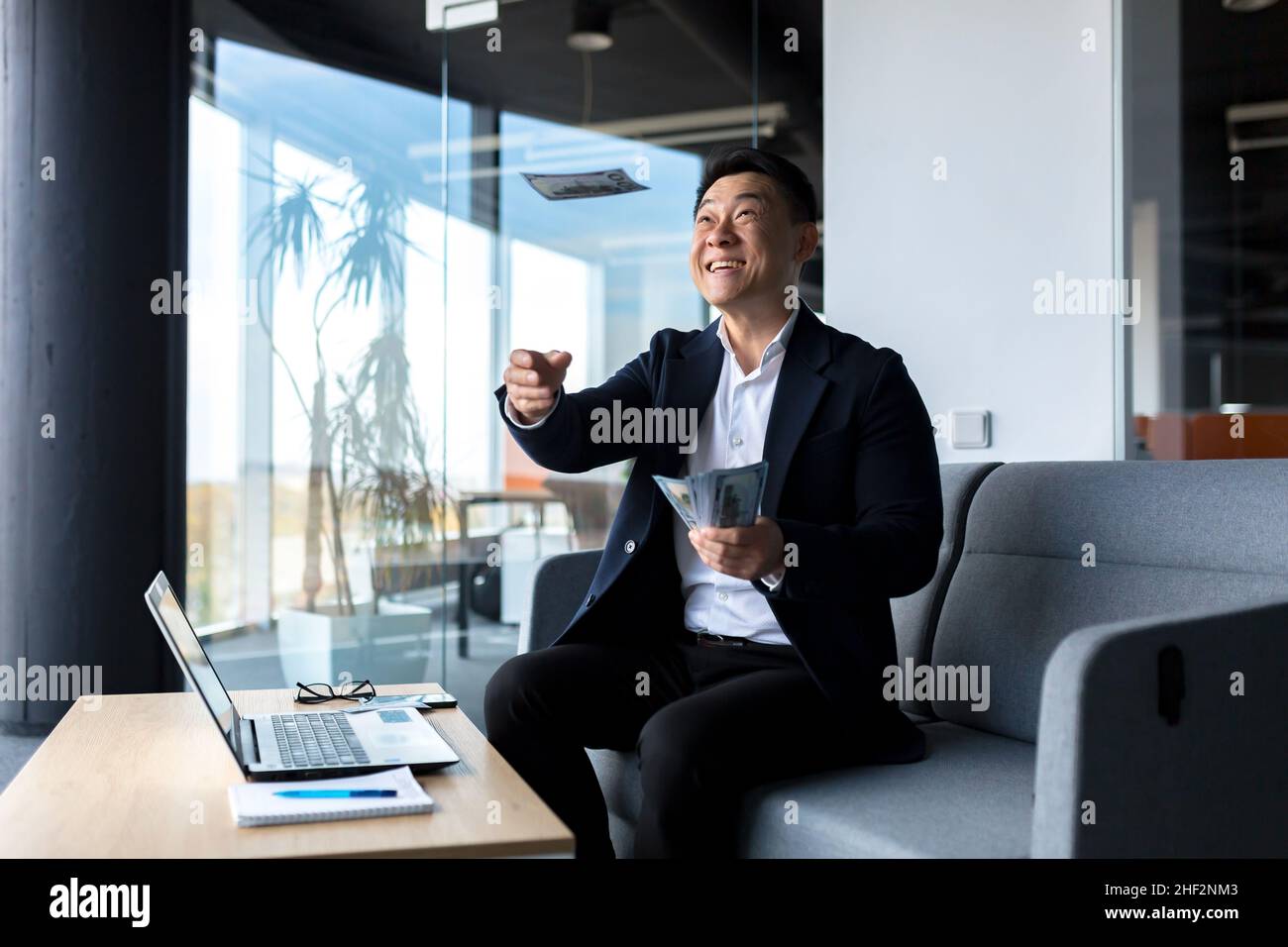 Happy and successful Asian, businessman working in office with laptop ...