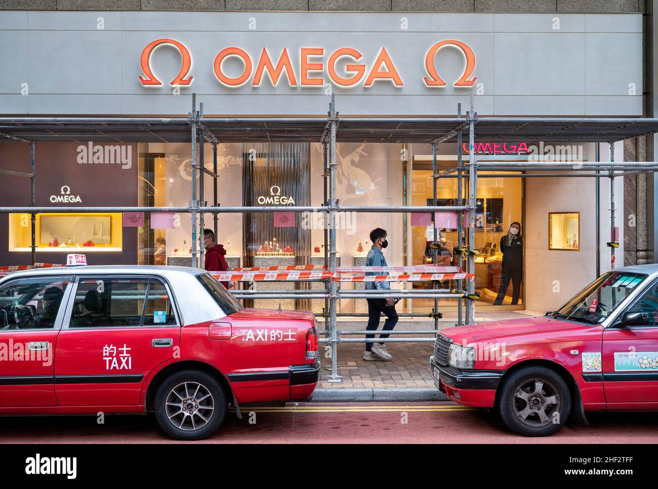 A pedestrian walks past the Swiss luxury watchmaker Omega store in Hong ...