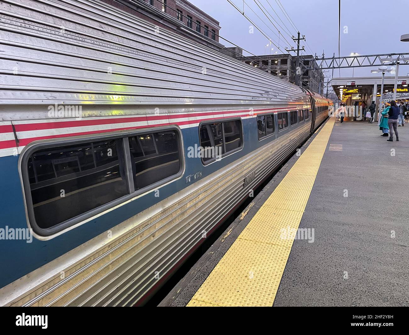 Passengers wait to board Amtrak train at dusk, New Haven, Connecticut Stock Photo