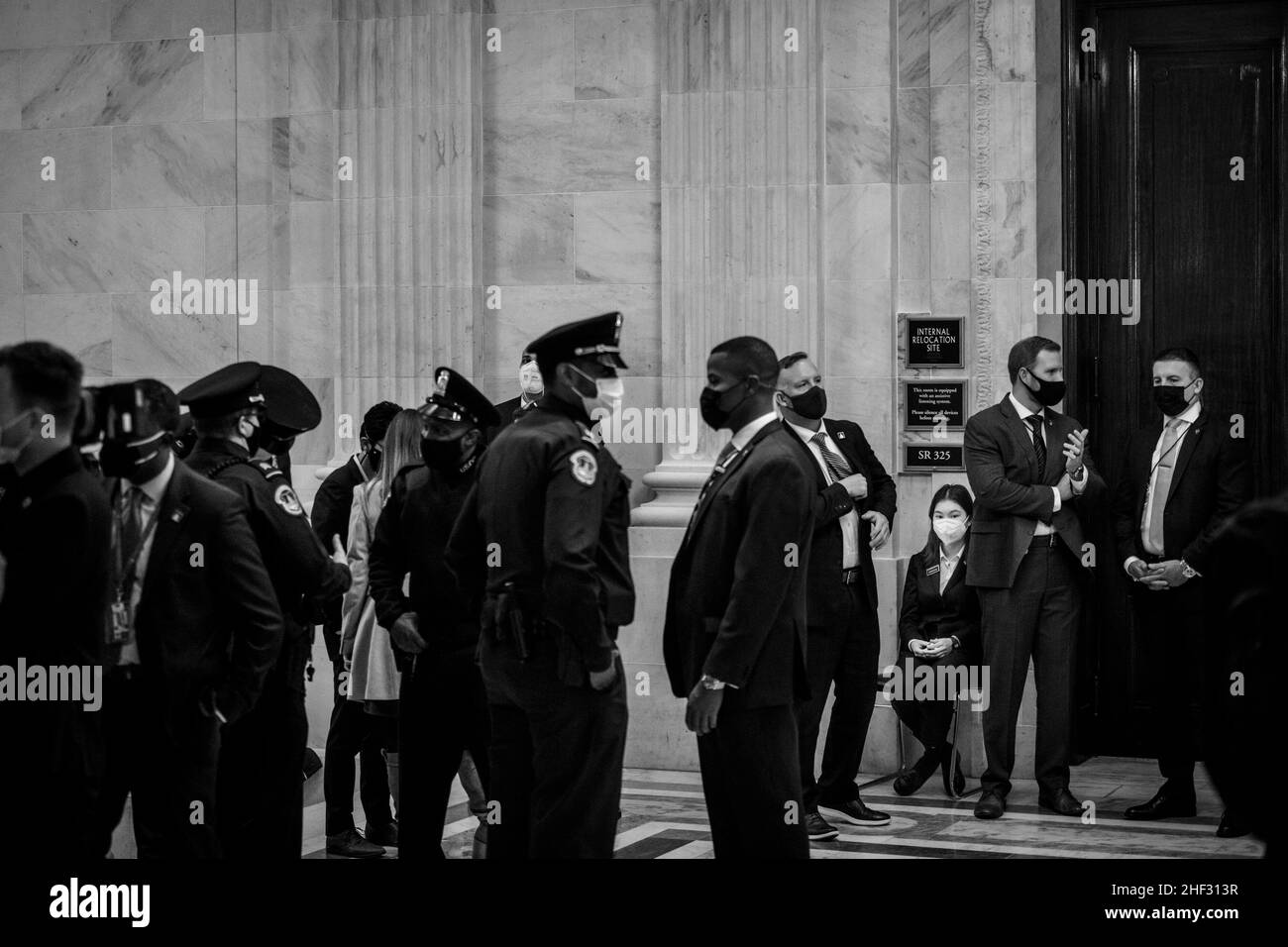 Washington, Vereinigte Staaten. 13th Jan, 2022. A page waits among US Capitol police and Secret Service agents, for the departure of United States President Joe Biden from a meeting with the Senate Democratic Caucus in the Russell Senate Office Building on Capitol Hill in Washington, DC, Thursday, January 13, 2022. Credit: Rod Lamkey/CNP/dpa/Alamy Live News Stock Photo