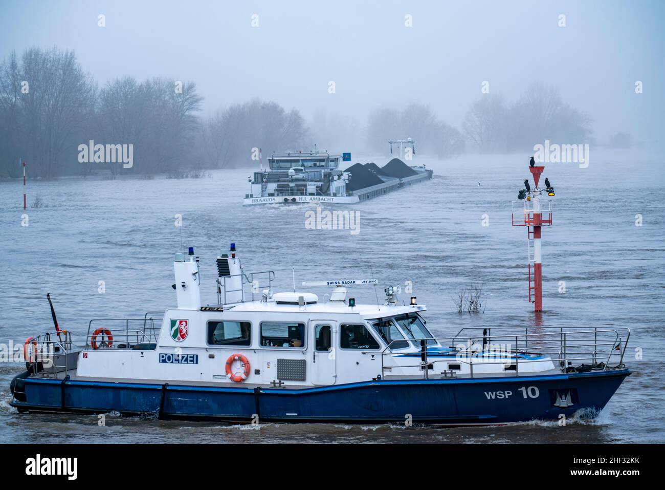 Dense fog, Rhine near DŸsseldorf, cargo ship heading south, in very low visibility, navigation signs with waterfowl, patrol boat of the water police, Stock Photo