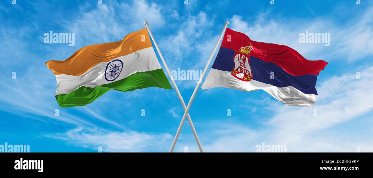 crossed national flags of India and Serbia flag waving in the wind at ...