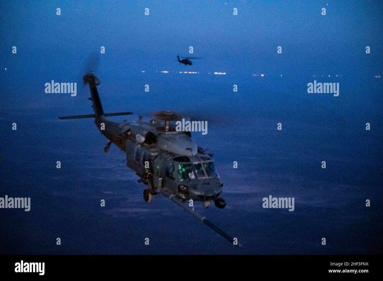 A U.S. Air Force HH-60 Pave Hawk assigned to the 46th Expeditionary Rescue Squadron receives fuel from a U.S. Air Force HC-130J Combat King II assigned to the 26th ERQS during a helicopter air-to-air refueling operation over the U.S. Central Commands area of responsibility, Jan. 3, 2021. The HH-60G Pave Hawk helicopter delivers U.S. Central Command the ability to conduct day or night personnel recovery operations into hostile environments to recover isolated U.S., partner nation, and foreign-national forces. (U.S. Air Force photo by Senior Airman Daniel Hernandez) Stock Photo