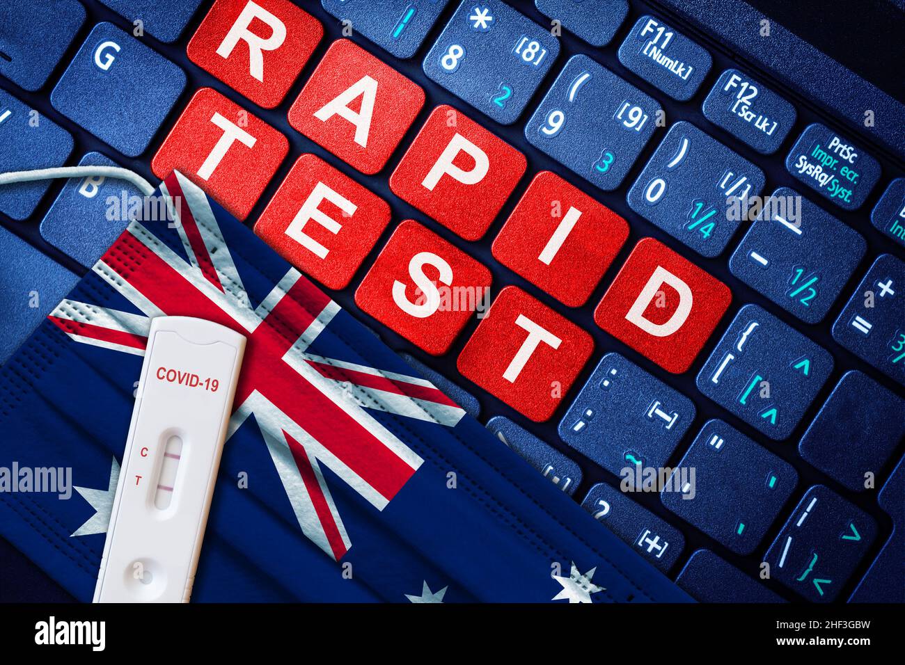 COVID-19 positive antigen rapid test kit on face mask with Australian flag on computer keyboard. Concept of home use Covid self testing in Australia. Stock Photo