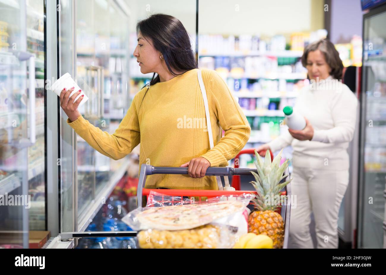 Latin american woman choosing dairy products in grocery shop Stock Photo Alamy