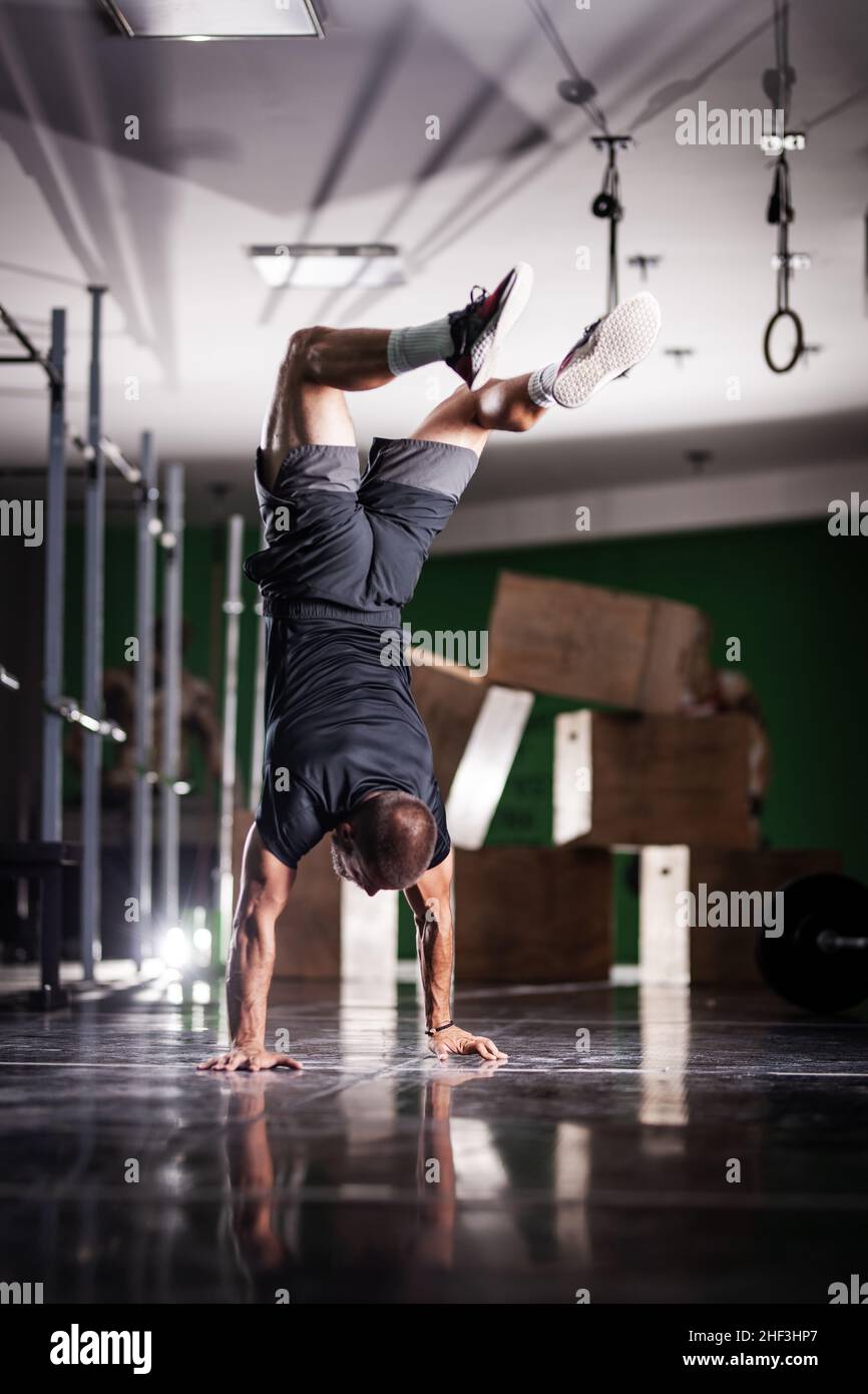 Muscular athlete standing and walking on hands upside down Stock Photo ...